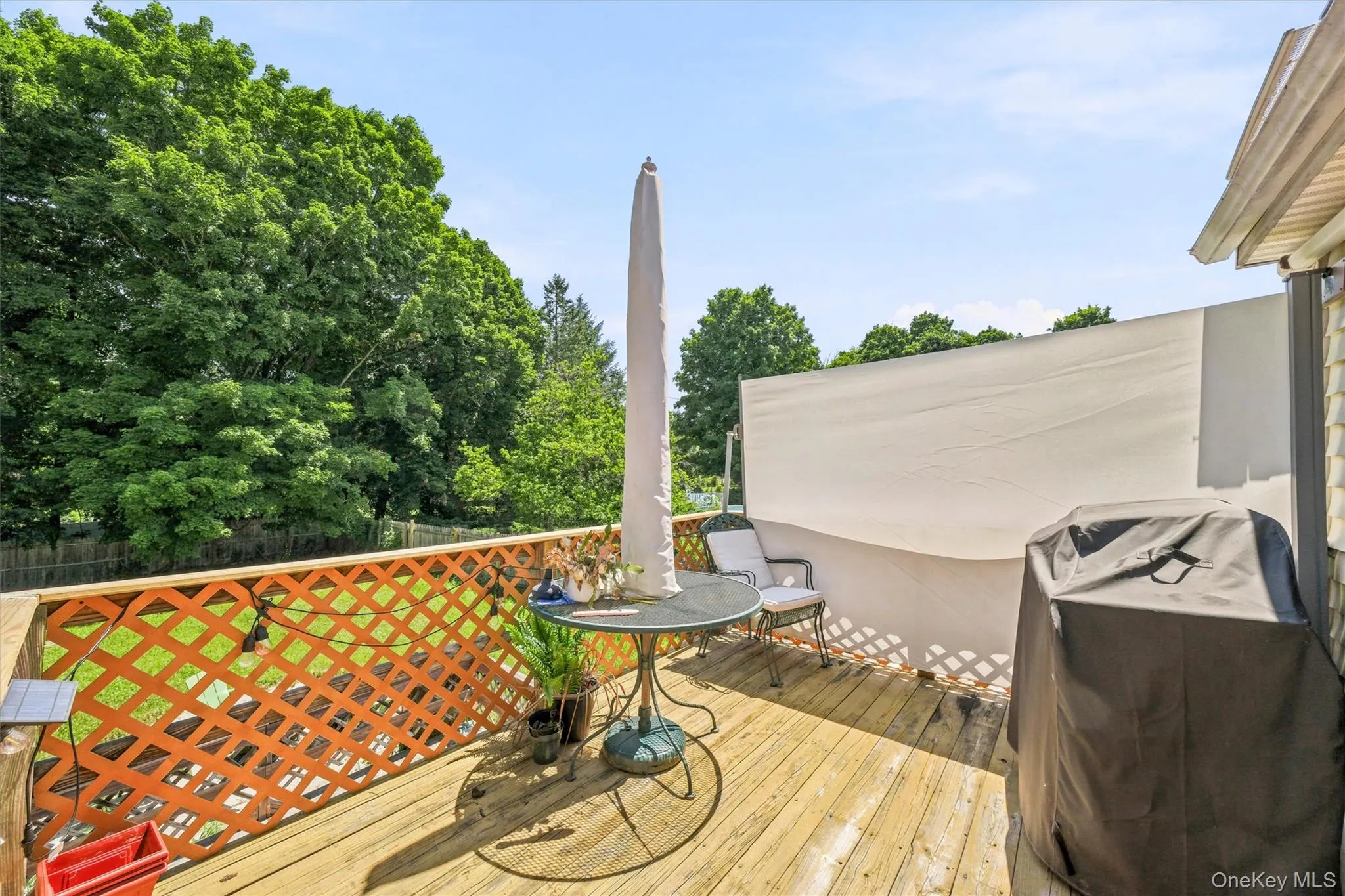 Expansive outdoor deck featuring wood flooring and a lattice railing Expansive outdoor deck featuring wood flooring and a lattice railing