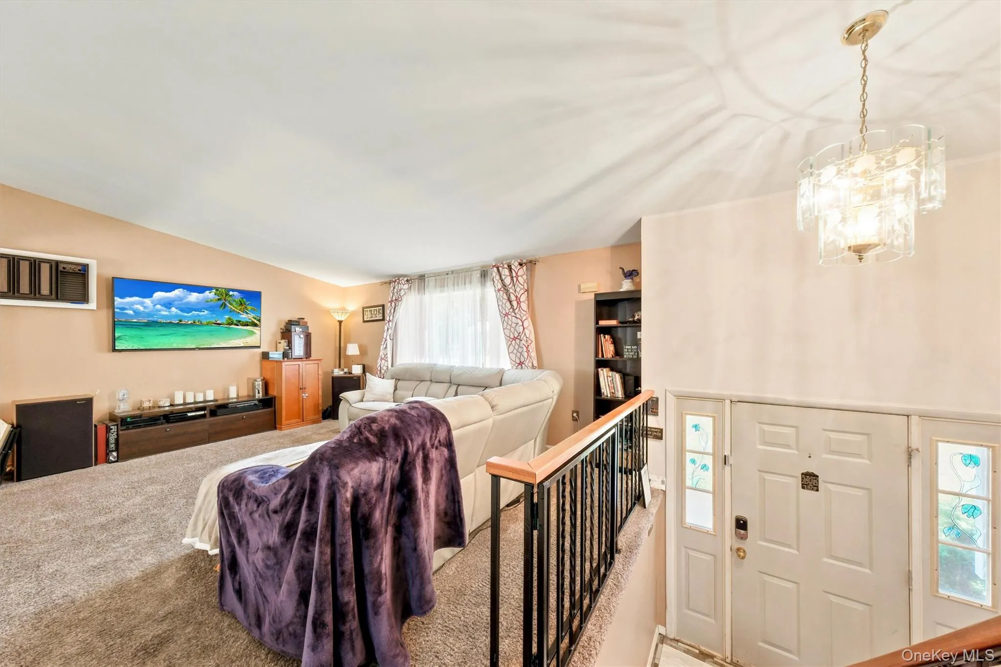 Entryway with a multi-paneled door featuring decorative glass sidelights, accompanied by a tiered glass chandelier Entryway with a multi-paneled door featuring decorative glass sidelights, accompanied by a tiered glass chandelier