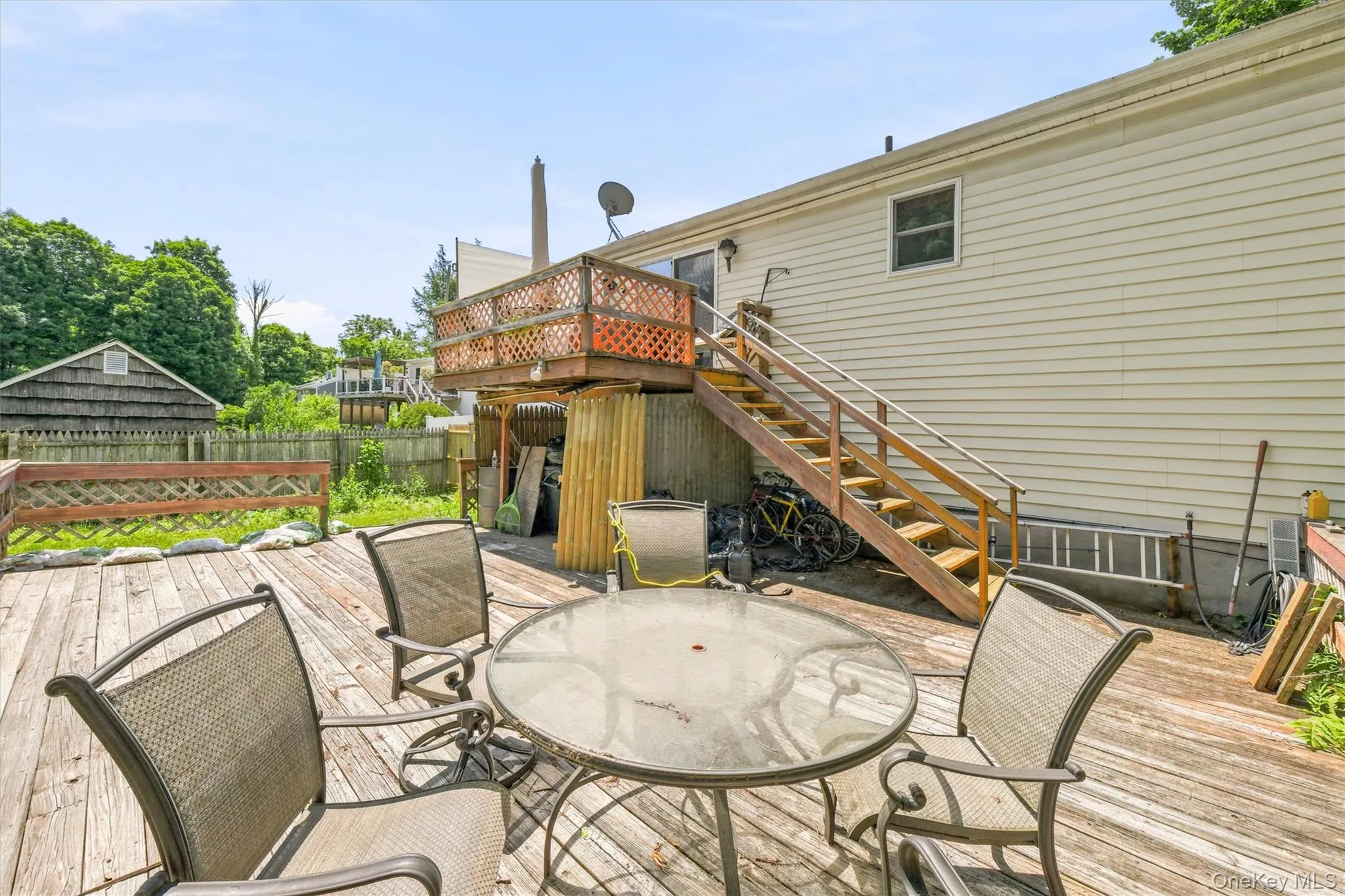 Expansive wood-finish deck with a built-in privacy railing, providing outdoor living space Expansive wood-finish deck with a built-in privacy railing, providing outdoor living space