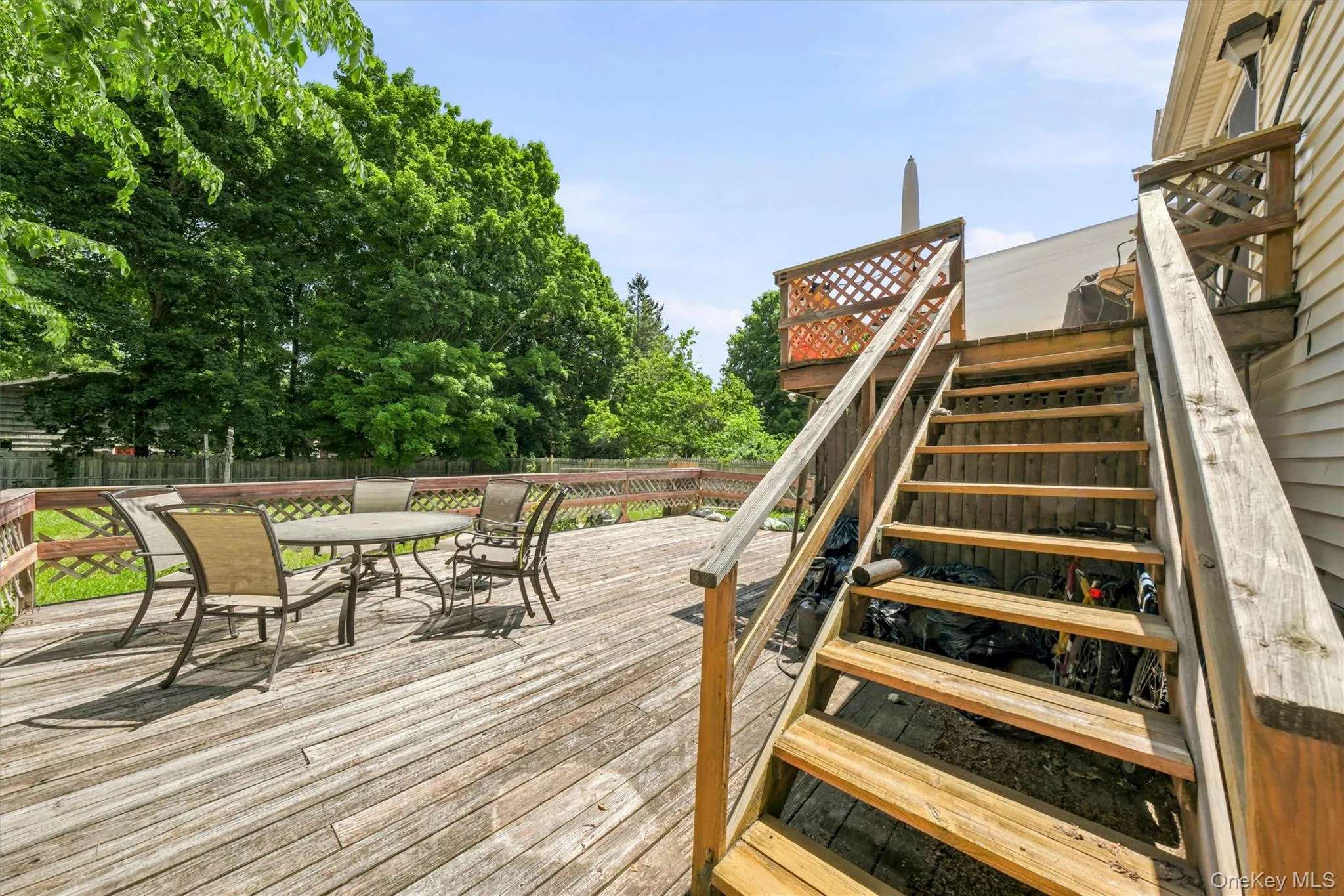 Multi-level wood deck featuring lattice railing, stairs, and a spacious lower section Multi-level wood deck featuring lattice railing, stairs, and a spacious lower section