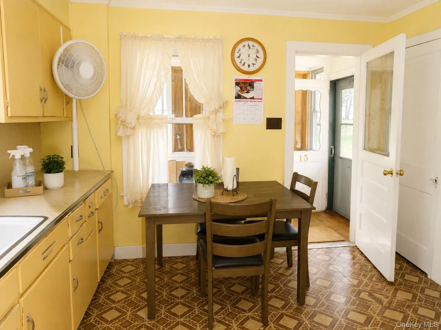 Kitchen featuring yellow cabinetry, a built-in sink, and patterned flooring Kitchen featuring yellow cabinetry, a built-in sink, and patterned flooring