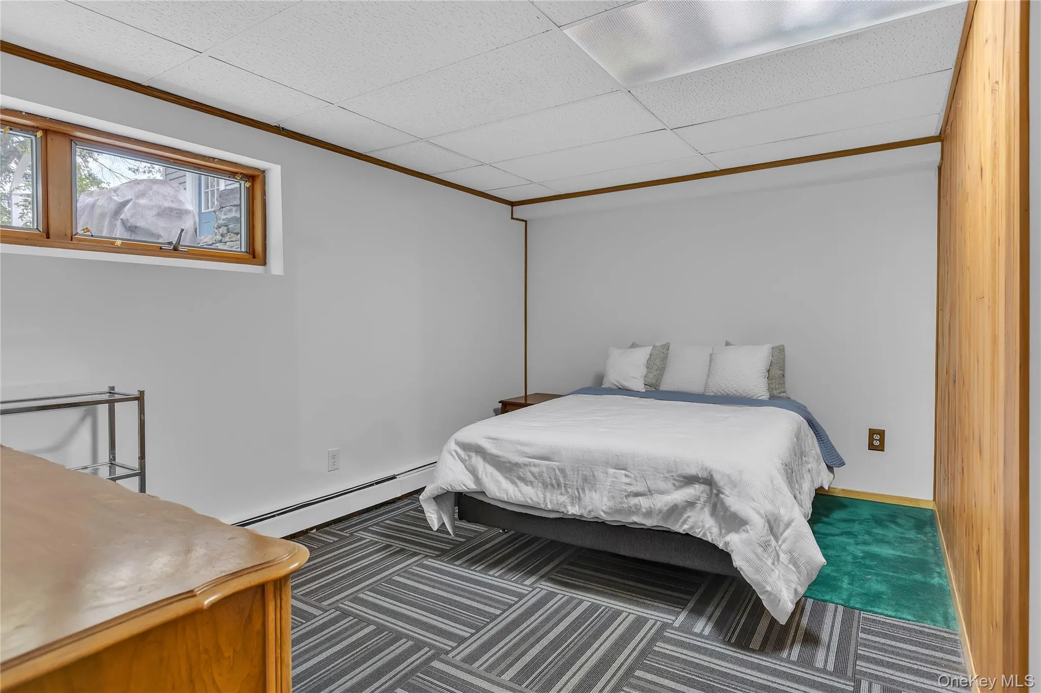 Room featuring a drop ceiling with recessed lighting, light gray painted walls, and wood-paneled accents Room featuring a drop ceiling with recessed lighting, light gray painted walls, and wood-paneled accents