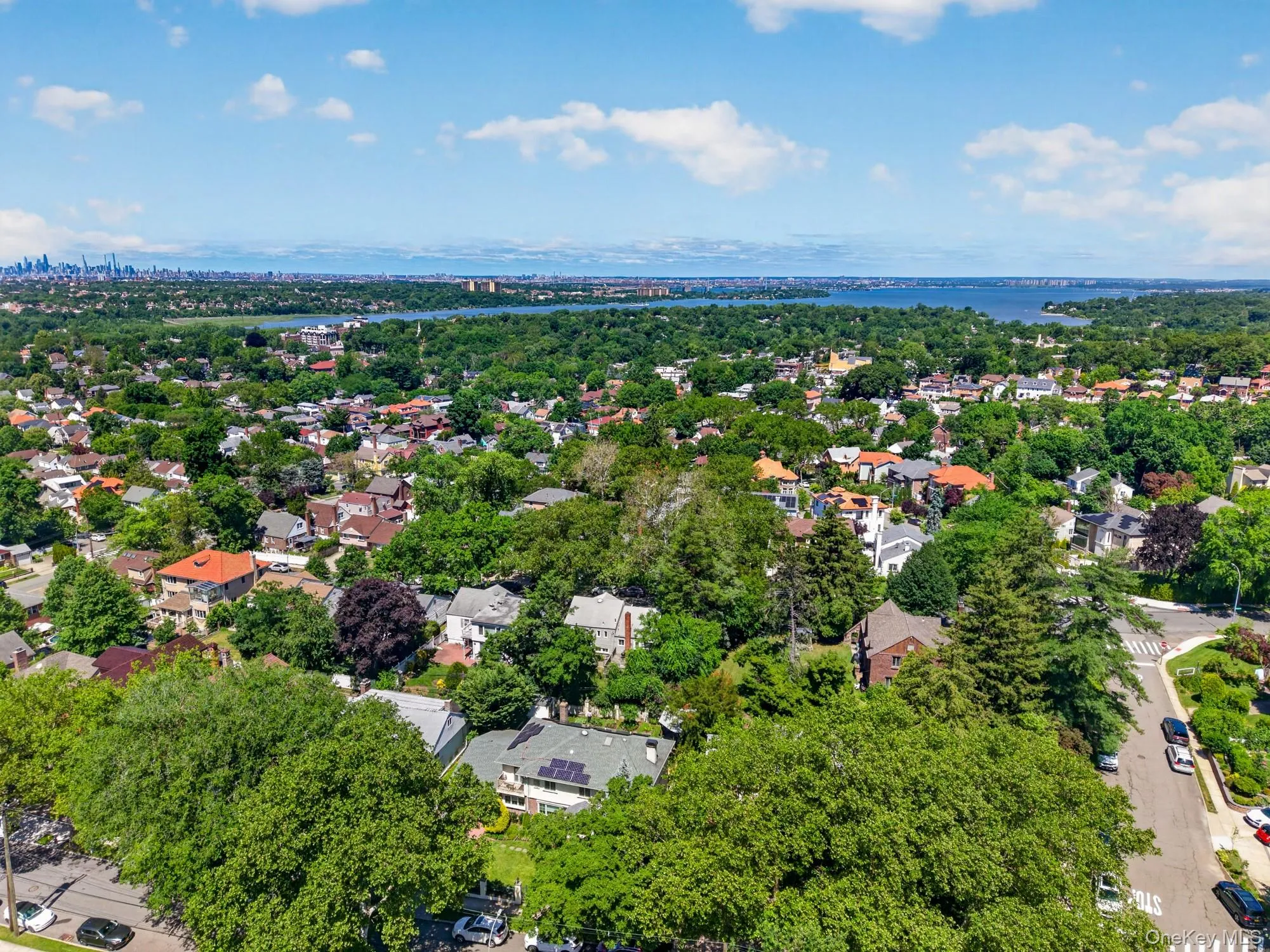 Aerial perspective showcasing a residential area with a prominent body of water in the distance Aerial perspective showcasing a residential area with a prominent body of water in the distance