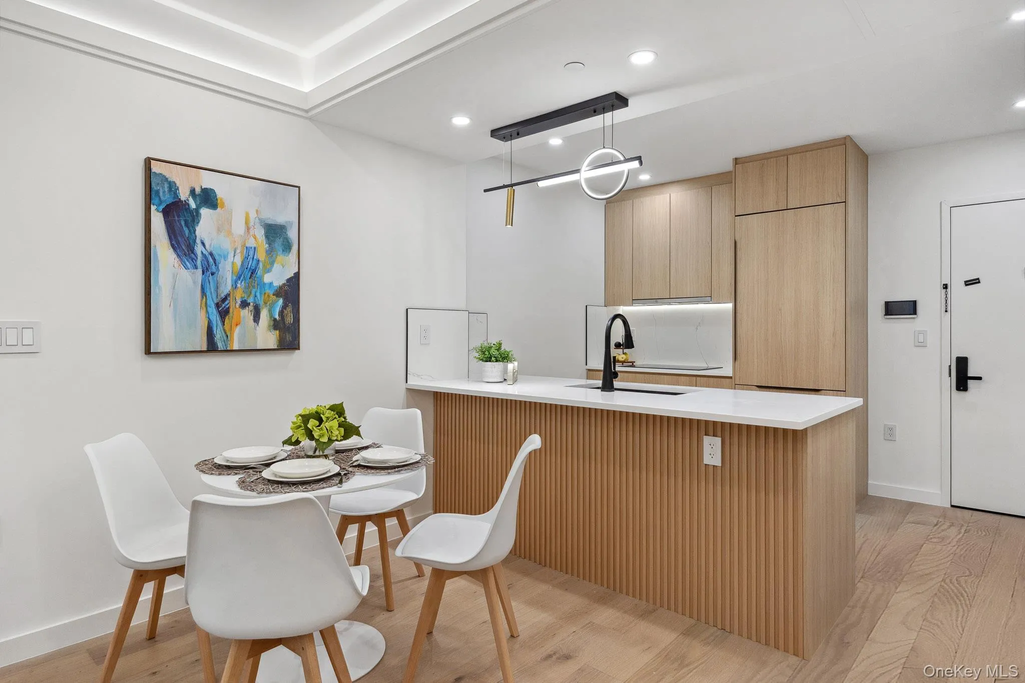 Kitchen featuring a sink, a peninsula, light wood-style flooring, recessed lighting, and light countertops Kitchen featuring a sink, a peninsula, light wood-style flooring, recessed lighting, and light countertops