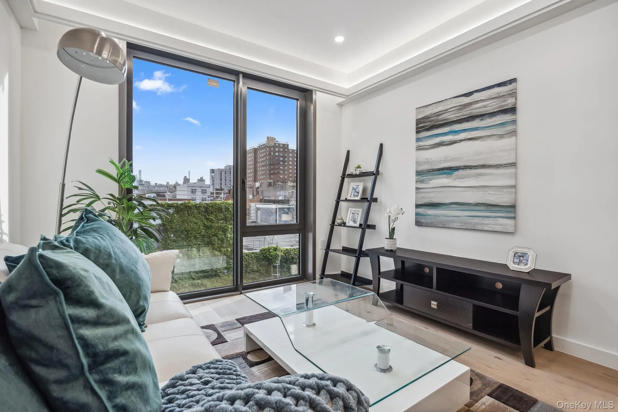 Living room with a view of city, healthy amount of natural light, wood finished floors, recessed lighting, and baseboards Living room with a view of city, healthy amount of natural light, wood finished floors, recessed lighting, and baseboards