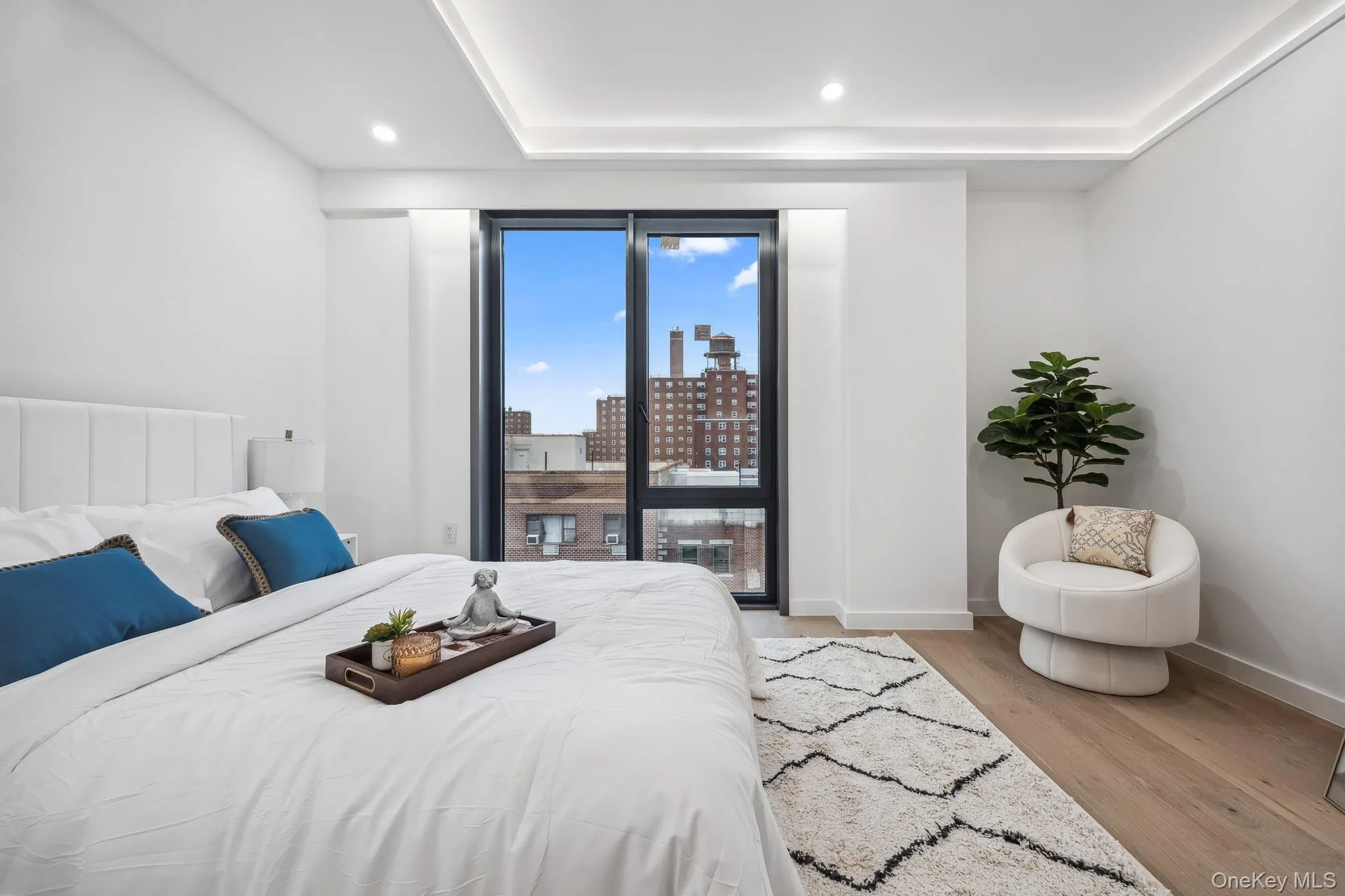 Bedroom with light wood-style flooring, baseboards, a city view, and recessed lighting Bedroom with light wood-style flooring, baseboards, a city view, and recessed lighting