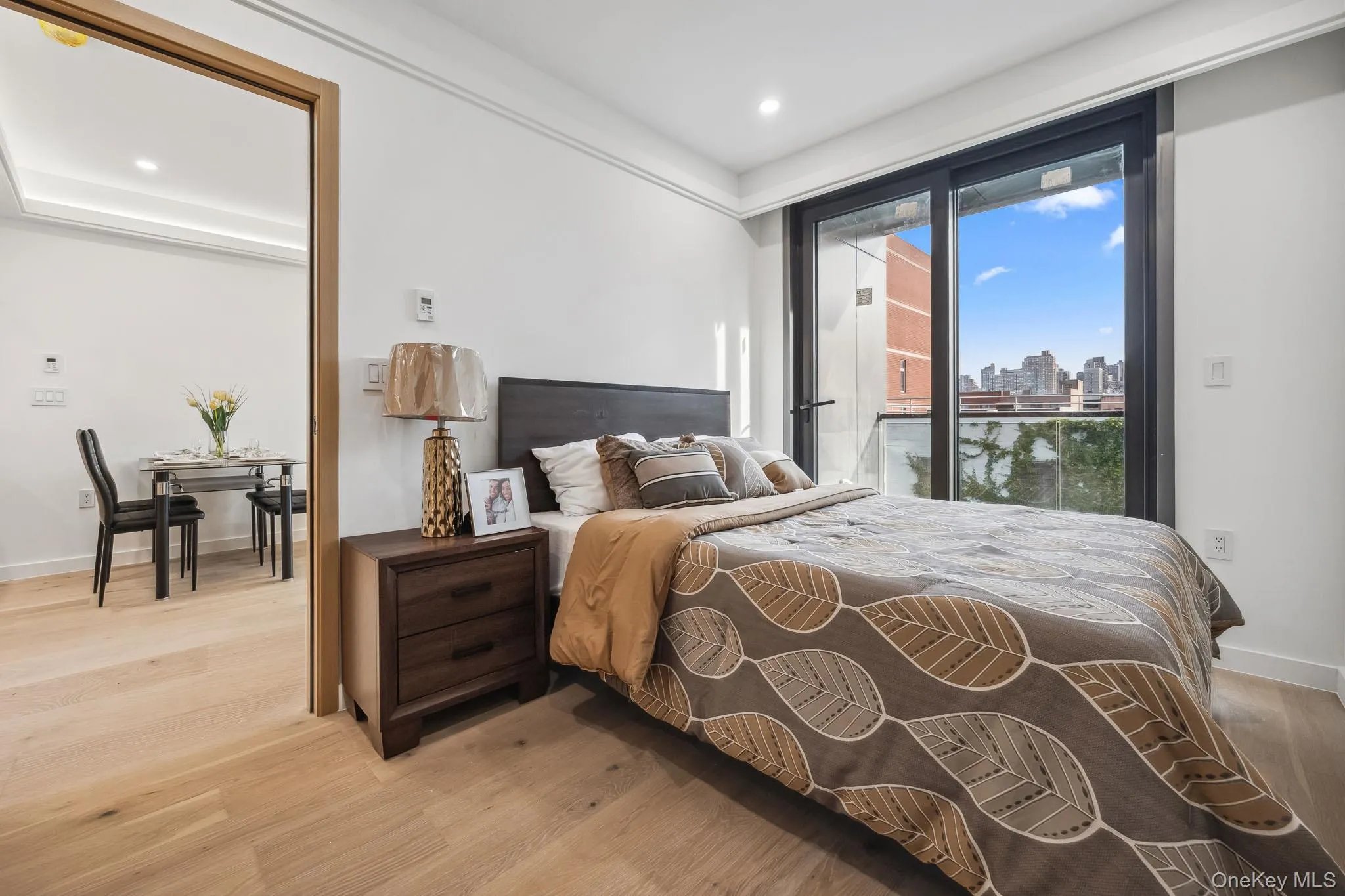 Bedroom featuring light wood-type flooring, a skyline view, recessed lighting, access to outside, and baseboards Bedroom featuring light wood-type flooring, a skyline view, recessed lighting, access to outside, and baseboards