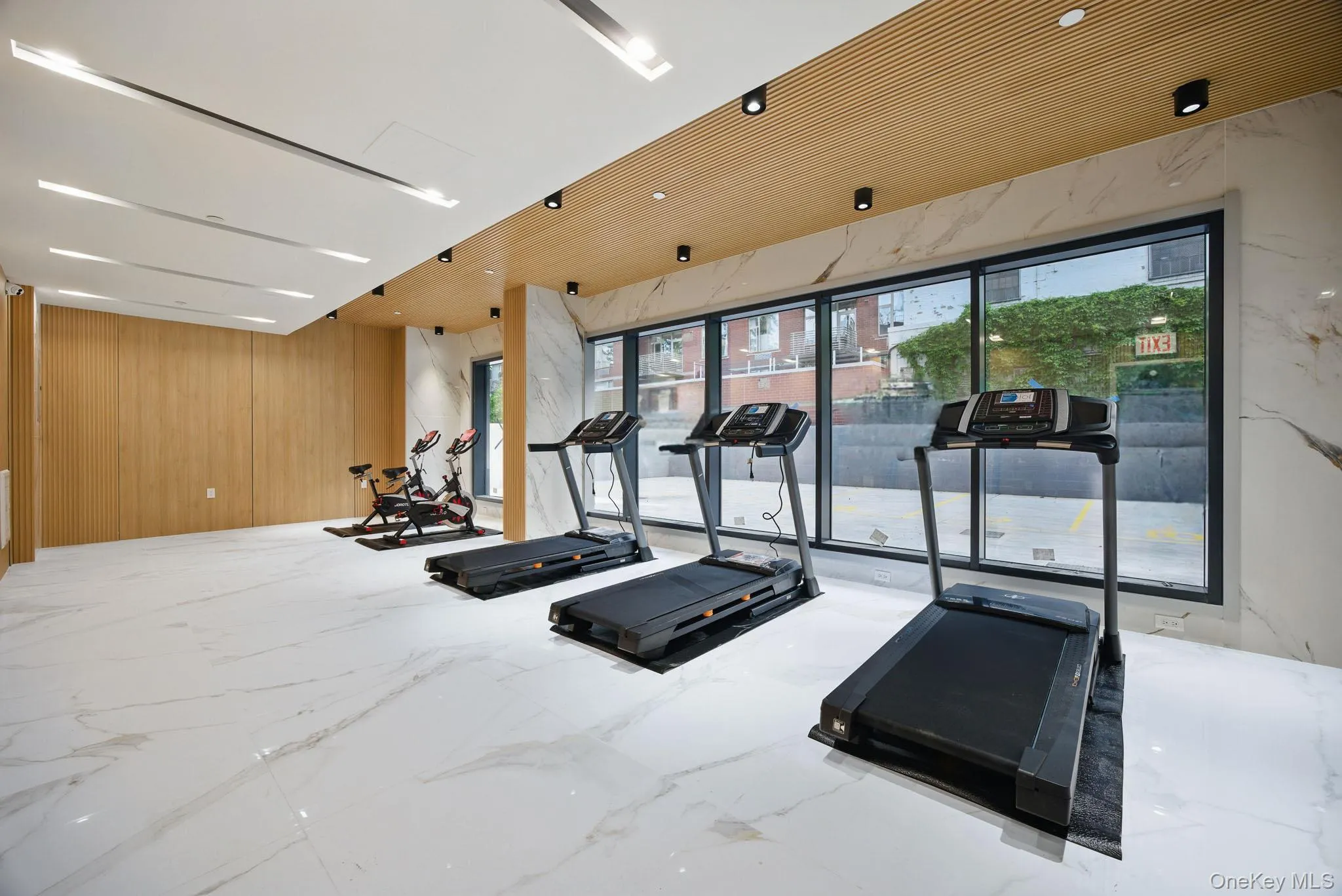 Workout area featuring wooden walls and marble finish floors Workout area featuring wooden walls and marble finish floors