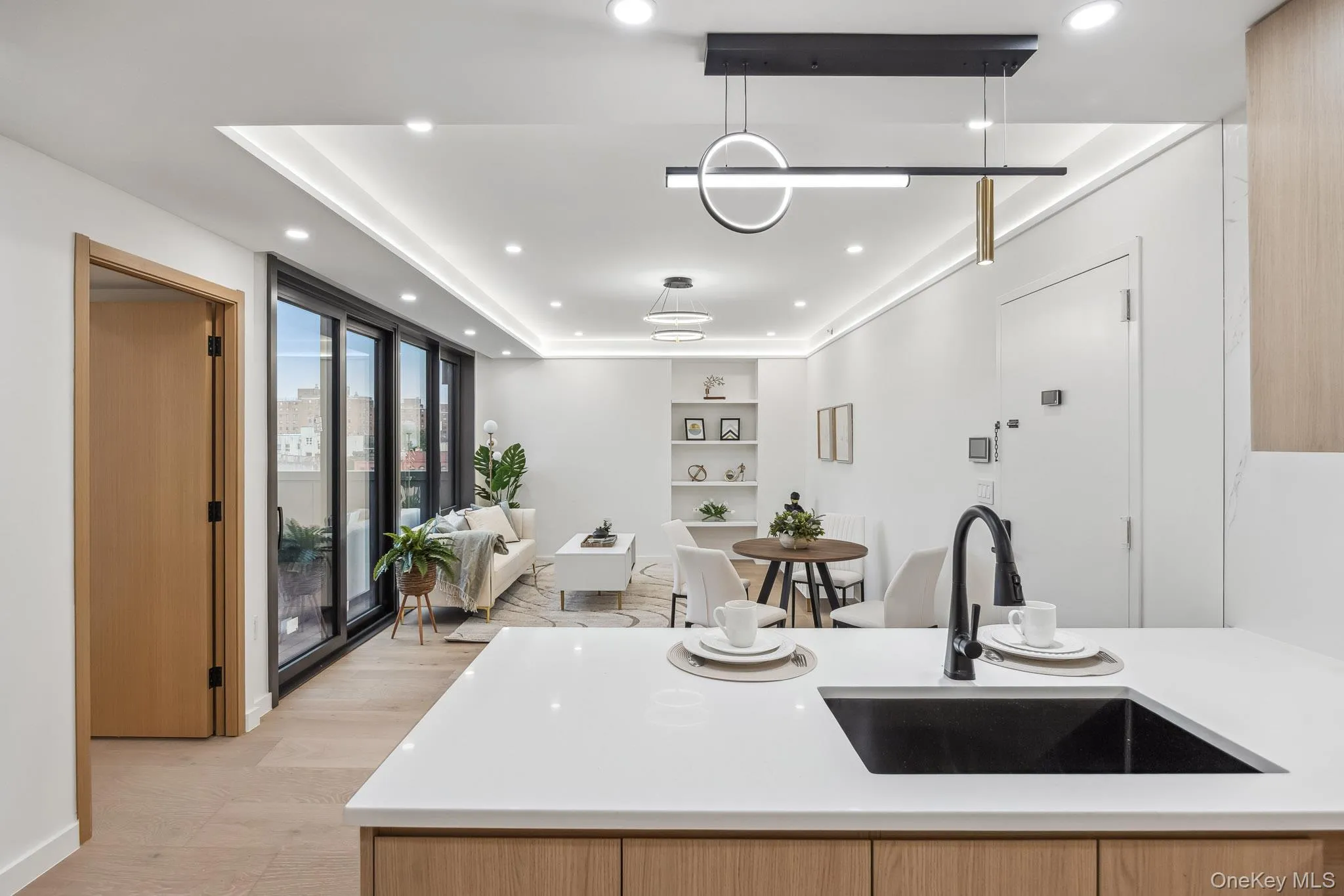 Kitchen with a sink, open floor plan, light countertops, recessed lighting, and decorative light fixtures Kitchen with a sink, open floor plan, light countertops, recessed lighting, and decorative light fixtures