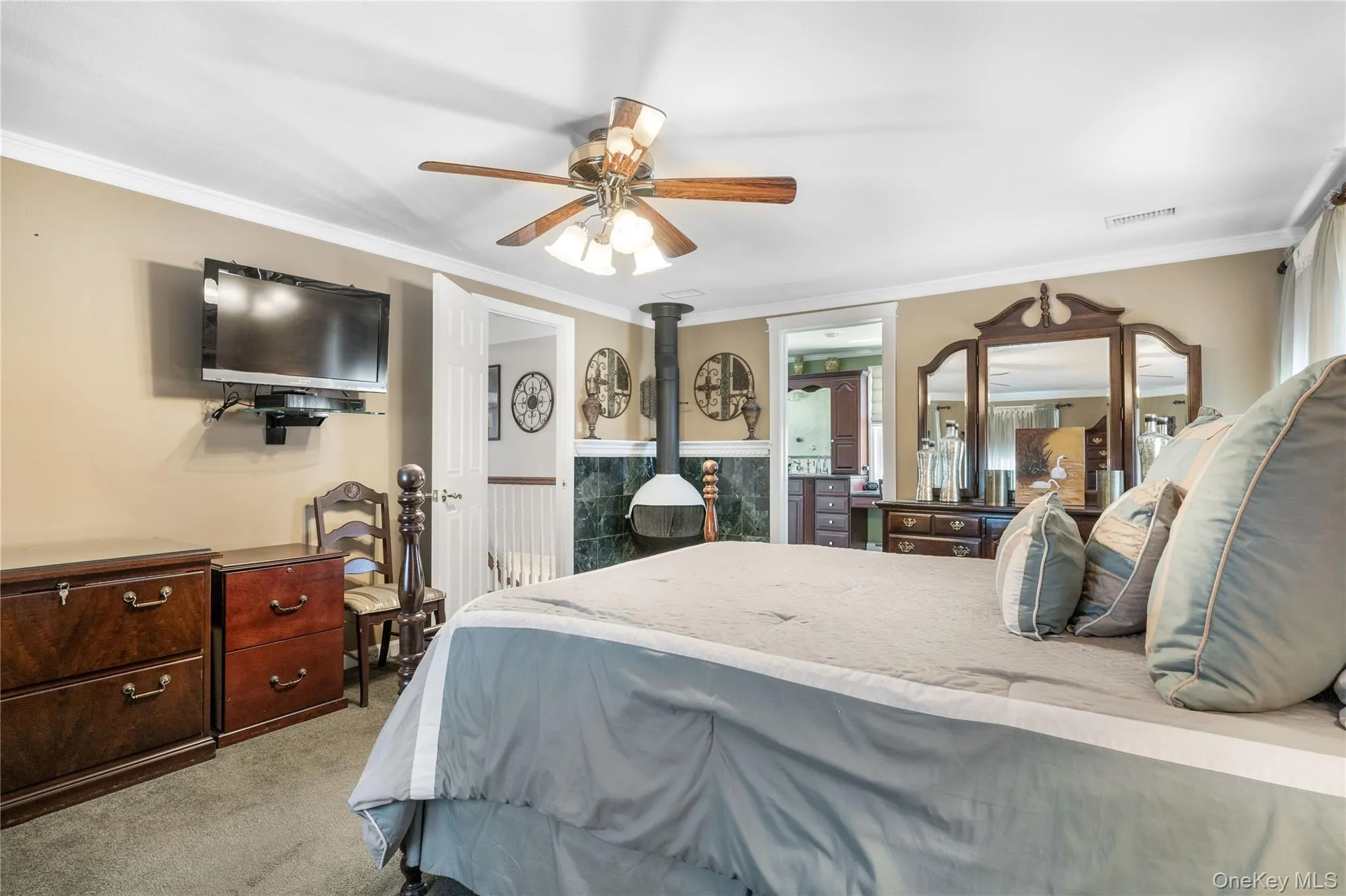 Spacious room featuring a ceiling fan, crown molding, and carpet flooring Spacious room featuring a ceiling fan, crown molding, and carpet flooring