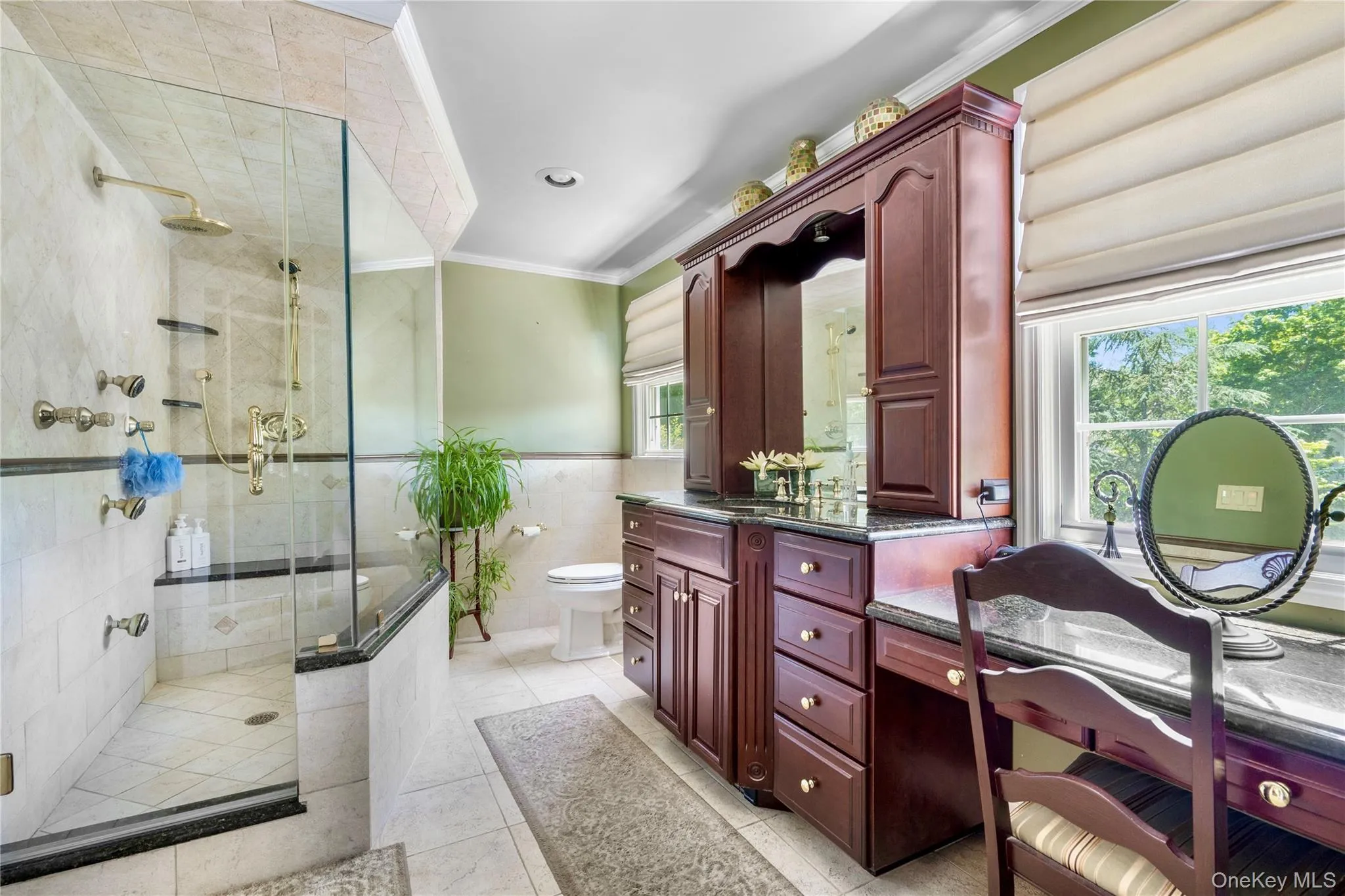 Walk-in shower with glass enclosure, built-in bench, and multiple brass fixtures Walk-in shower with glass enclosure, built-in bench, and multiple brass fixtures
