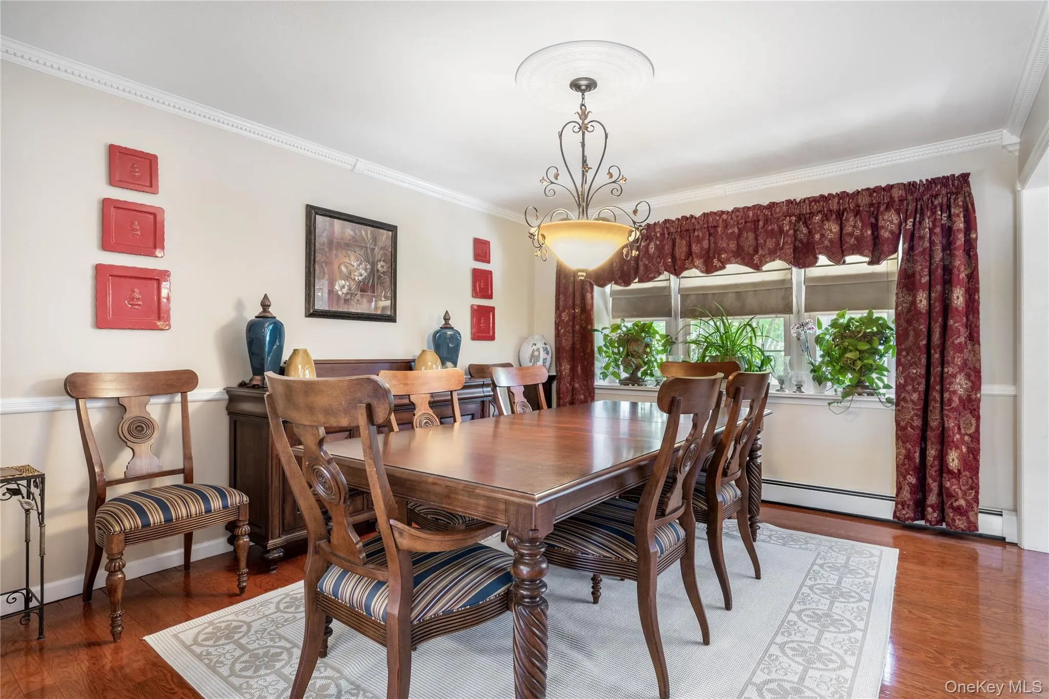 Dining area featuring wood-finish flooring, crown molding, and a decorative ceiling medallion with an attached chandelier Dining area featuring wood-finish flooring, crown molding, and a decorative ceiling medallion with an attached chandelier