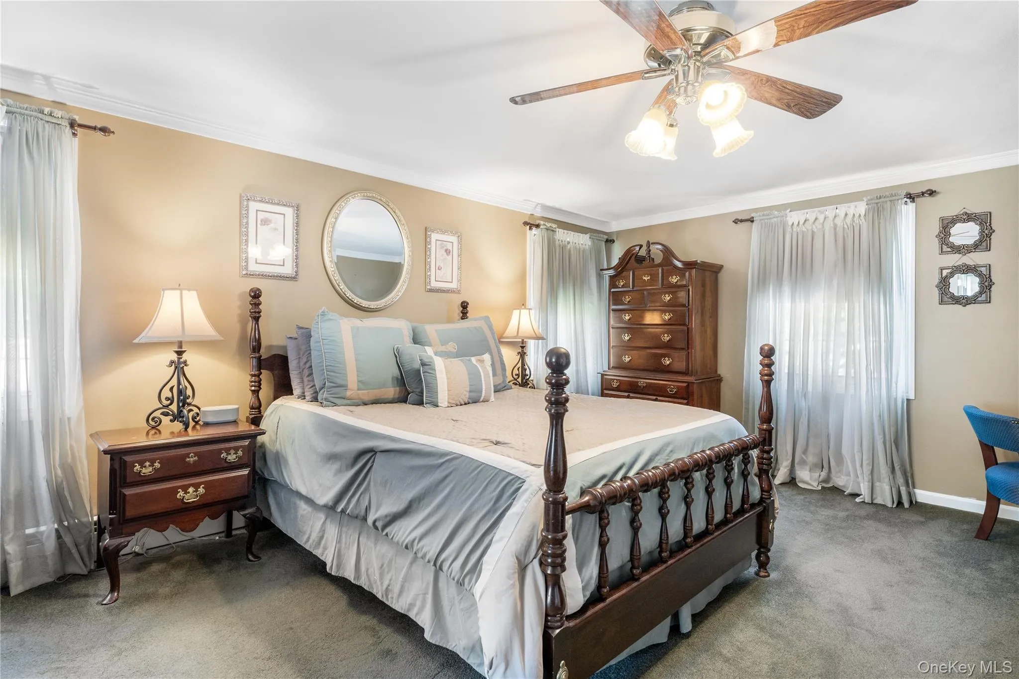 Carpeted room featuring crown molding, neutral wall tones, and a ceiling fan with light fixture Carpeted room featuring crown molding, neutral wall tones, and a ceiling fan with light fixture