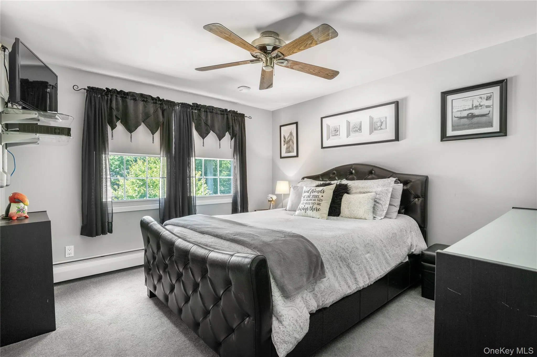 Carpeted interior space featuring light gray walls, white trim, and a ceiling fan with wood-finish blades Carpeted interior space featuring light gray walls, white trim, and a ceiling fan with wood-finish blades