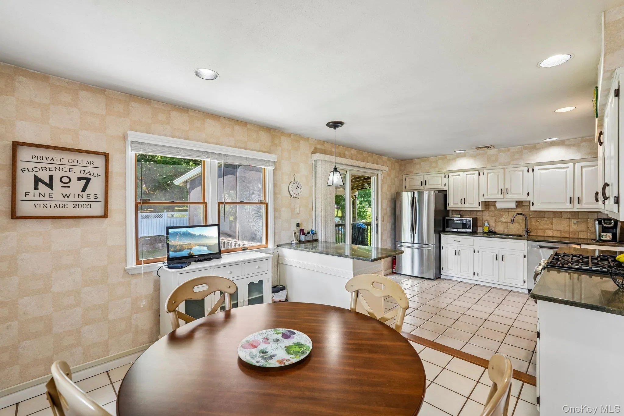 Kitchen featuring white cabinetry, tile flooring, and dark countertops Kitchen featuring white cabinetry, tile flooring, and dark countertops