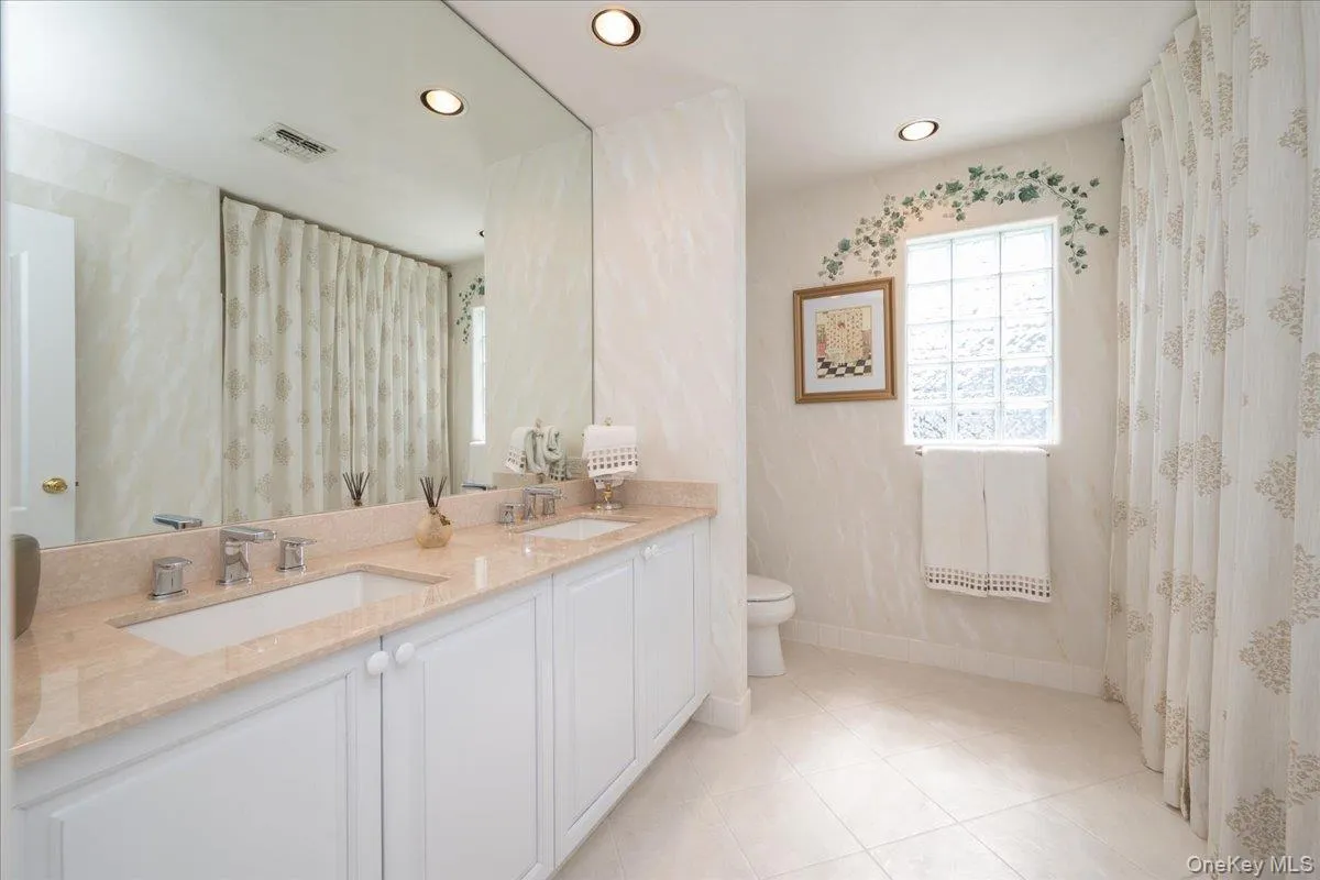 Full Bathroom with Dual vanity with integrated sinks and a light-toned countertop Full Bathroom with Dual vanity with integrated sinks and a light-toned countertop