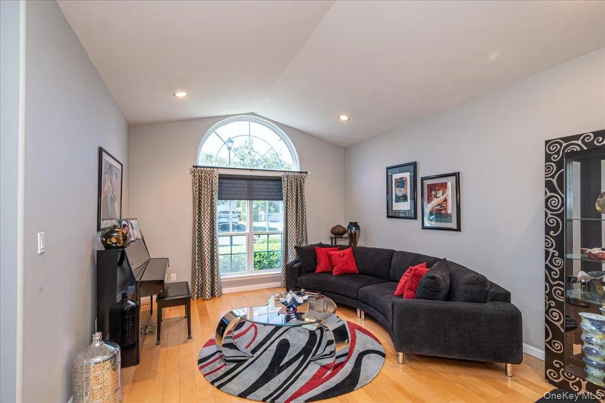 Living Room featuring wood-finish flooring, vaulted ceiling, and recessed lighting Living Room featuring wood-finish flooring, vaulted ceiling, and recessed lighting