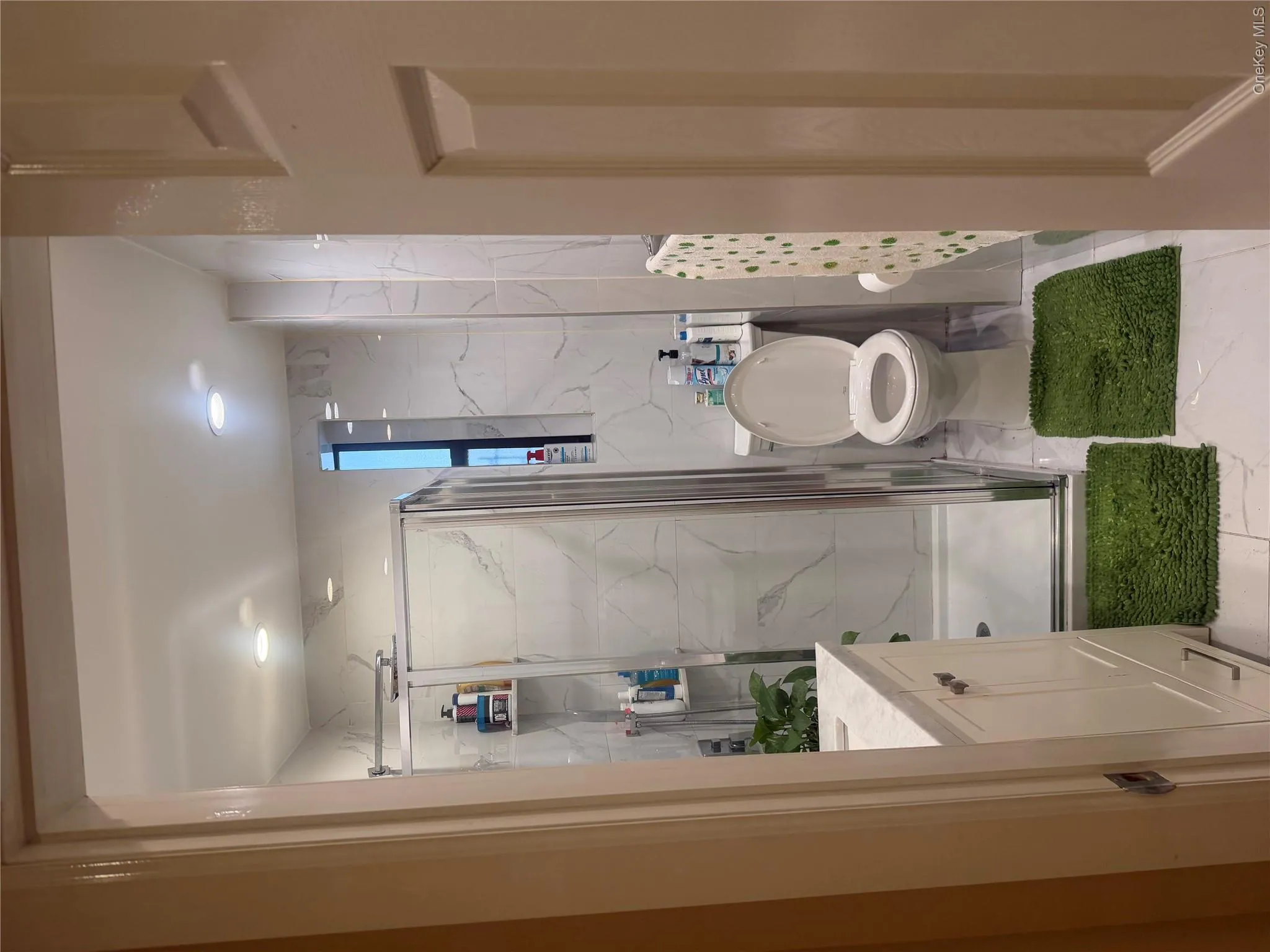Standup shower, marble tile walls throughout. Standup shower, marble tile walls throughout.