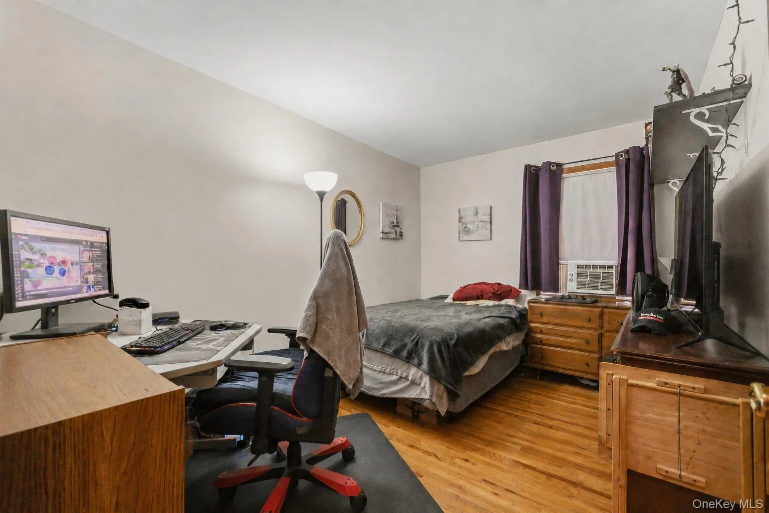 Bedroom featuring hardwood flooring, window, and neutral wall tones Bedroom featuring hardwood flooring, window, and neutral wall tones