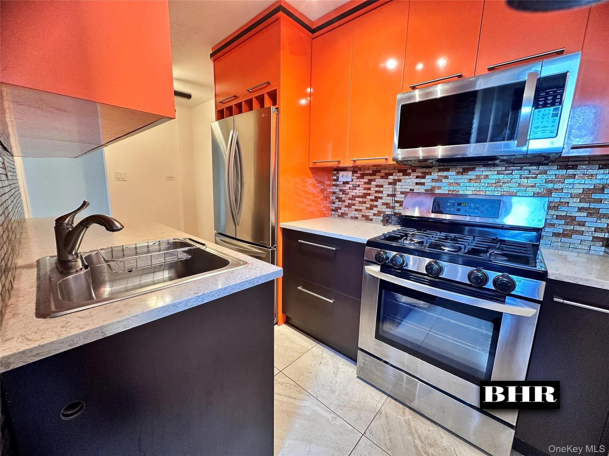 Kitchen featuring appliances with stainless steel finishes, decorative backsplash, and modern cabinets Kitchen featuring appliances with stainless steel finishes, decorative backsplash, and modern cabinets