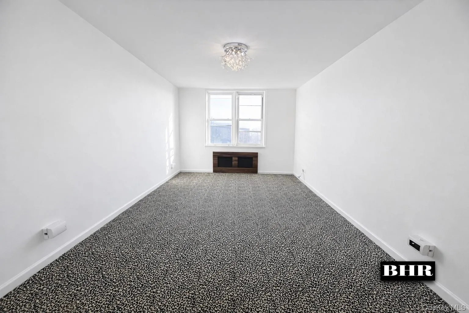 Carpeted spare room featuring baseboards and a chandelier Carpeted spare room featuring baseboards and a chandelier