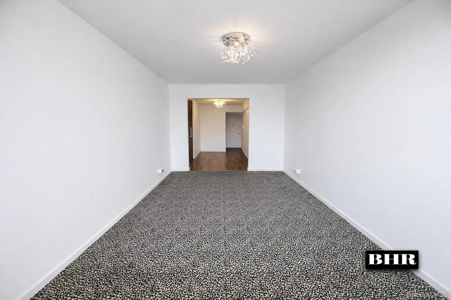 Spare room with a chandelier and dark colored carpet Spare room with a chandelier and dark colored carpet