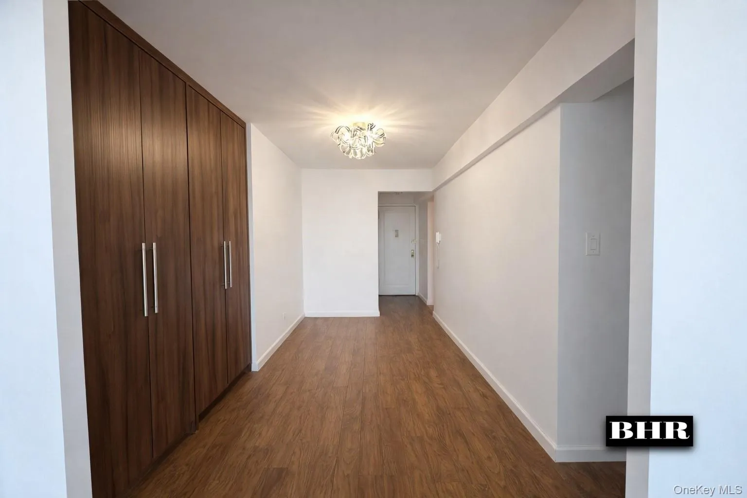 Hall featuring a chandelier and dark wood-style flooring Hall featuring a chandelier and dark wood-style flooring