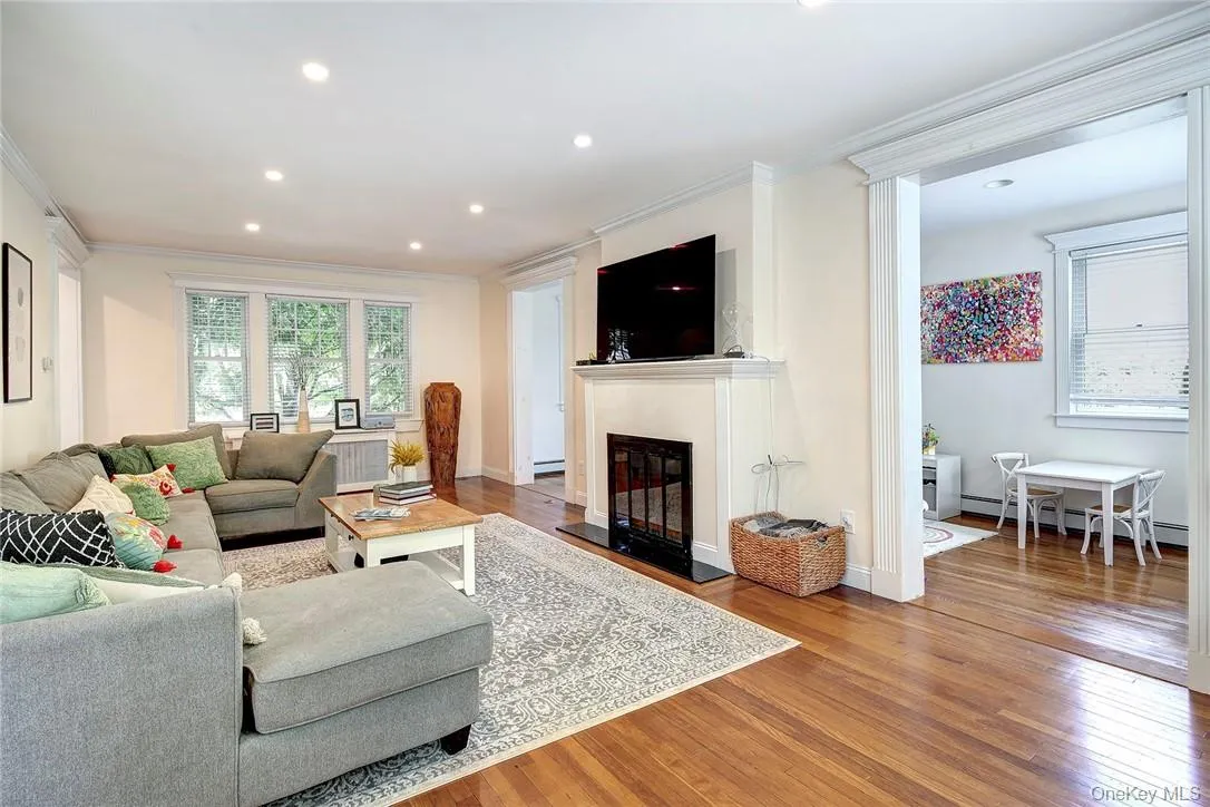 Living room with hardwood / wood flooring, ornamental molding, a glass covered fireplace, recessed lighting Living room with hardwood / wood flooring, ornamental molding, a glass covered fireplace, recessed lighting