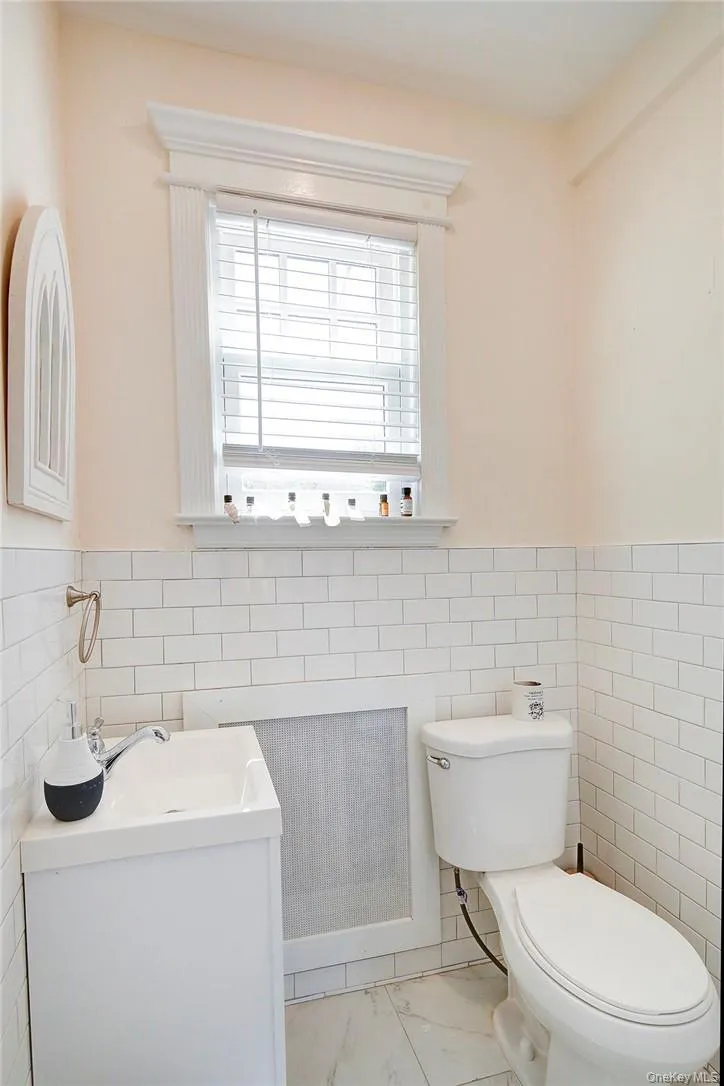 Updated Powder Room with tile walls, wainscoting, and vanity Updated Powder Room with tile walls, wainscoting, and vanity