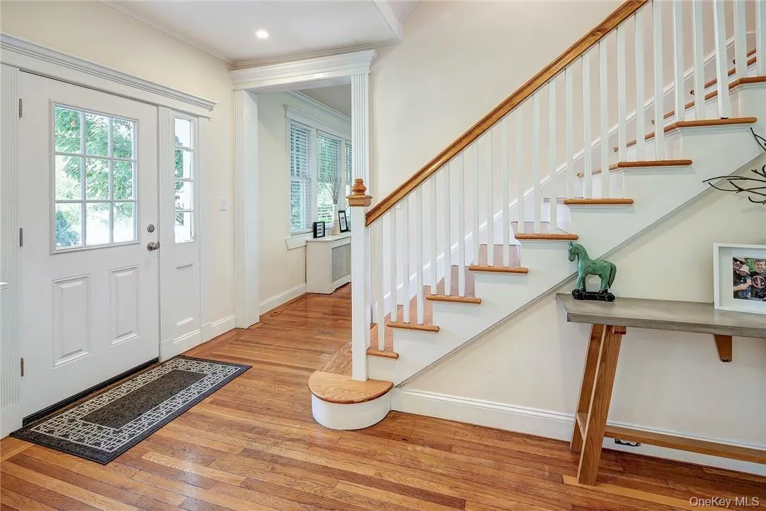 Center Hall featuring light hardwood floors and ornamental molding Center Hall featuring light hardwood floors and ornamental molding
