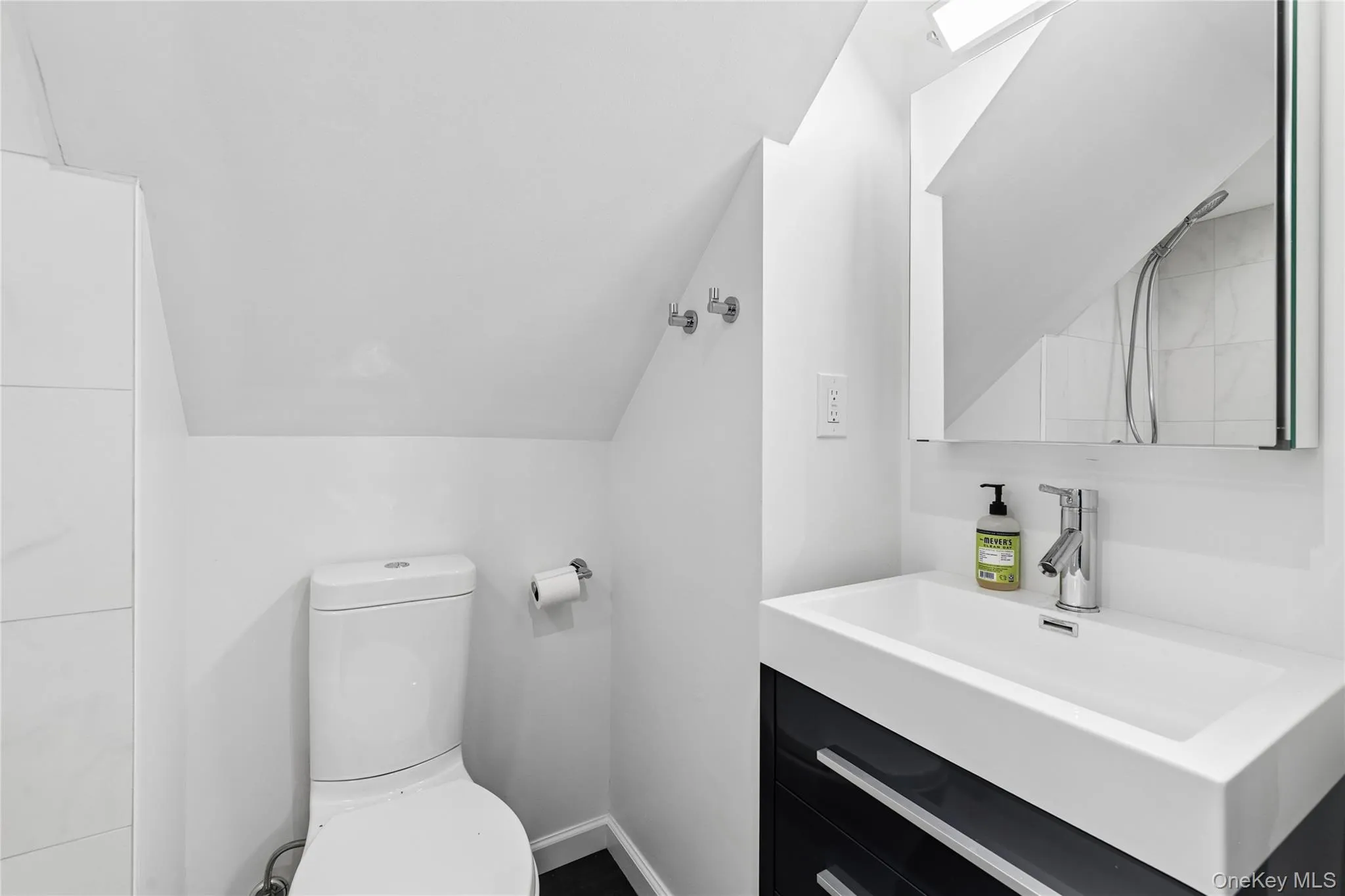 Modern bathroom featuring a contemporary vanity with an integrated sink, chrome faucet, and a wall-mounted mirror Modern bathroom featuring a contemporary vanity with an integrated sink, chrome faucet, and a wall-mounted mirror