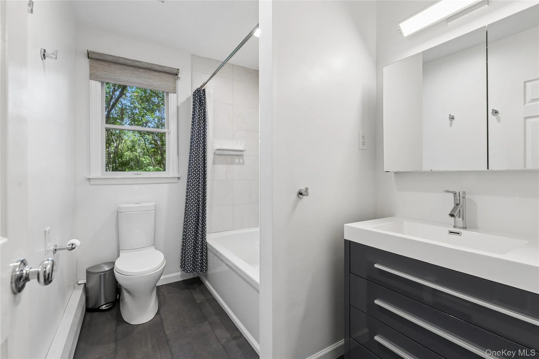 Bathroom featuring a modern vanity with integrated sink, chrome faucet, and mirrored medicine cabinet Bathroom featuring a modern vanity with integrated sink, chrome faucet, and mirrored medicine cabinet