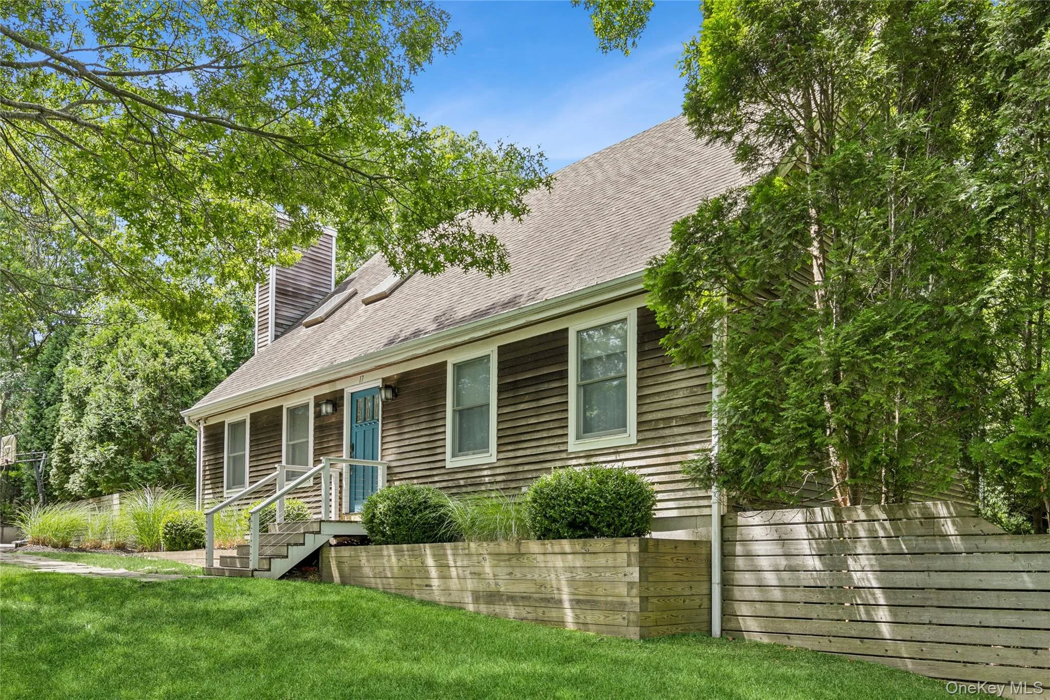 Shingled exterior featuring a light blue entry door, white trim, and a shingle roof Shingled exterior featuring a light blue entry door, white trim, and a shingle roof
