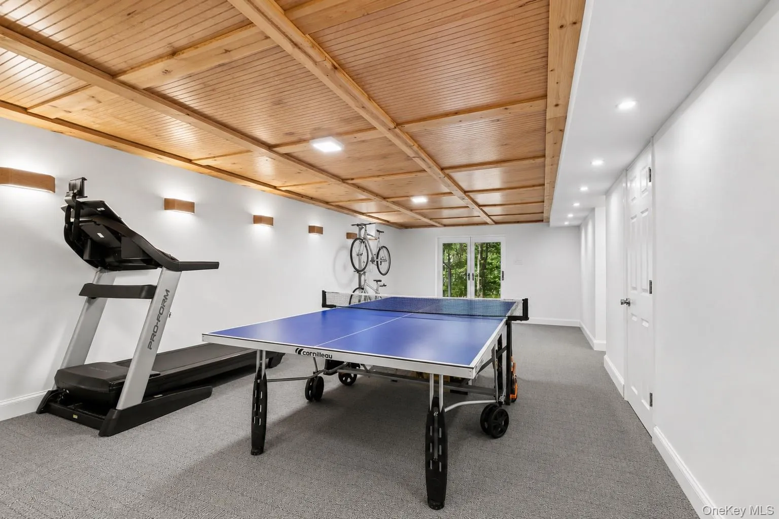 Recreation room featuring a wood-panel ceiling, recessed lighting, and wall sconces Recreation room featuring a wood-panel ceiling, recessed lighting, and wall sconces