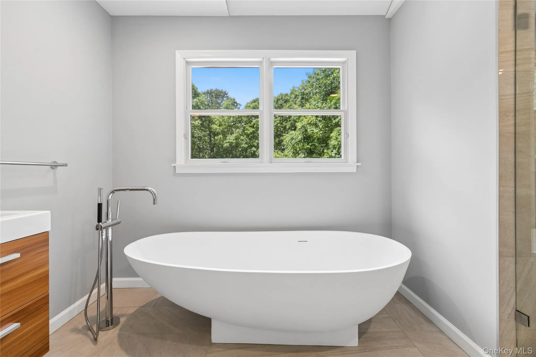 Freestanding soaking tub with a floor-mounted chrome filler Freestanding soaking tub with a floor-mounted chrome filler