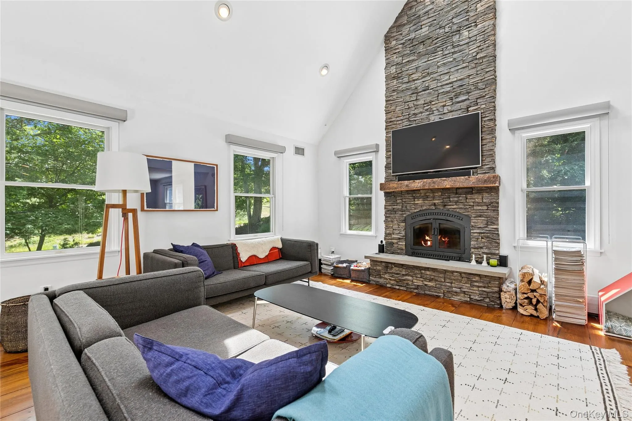 Living area featuring a floor-to-ceiling stone wood fireplace with a wood mantel Living area featuring a floor-to-ceiling stone wood fireplace with a wood mantel