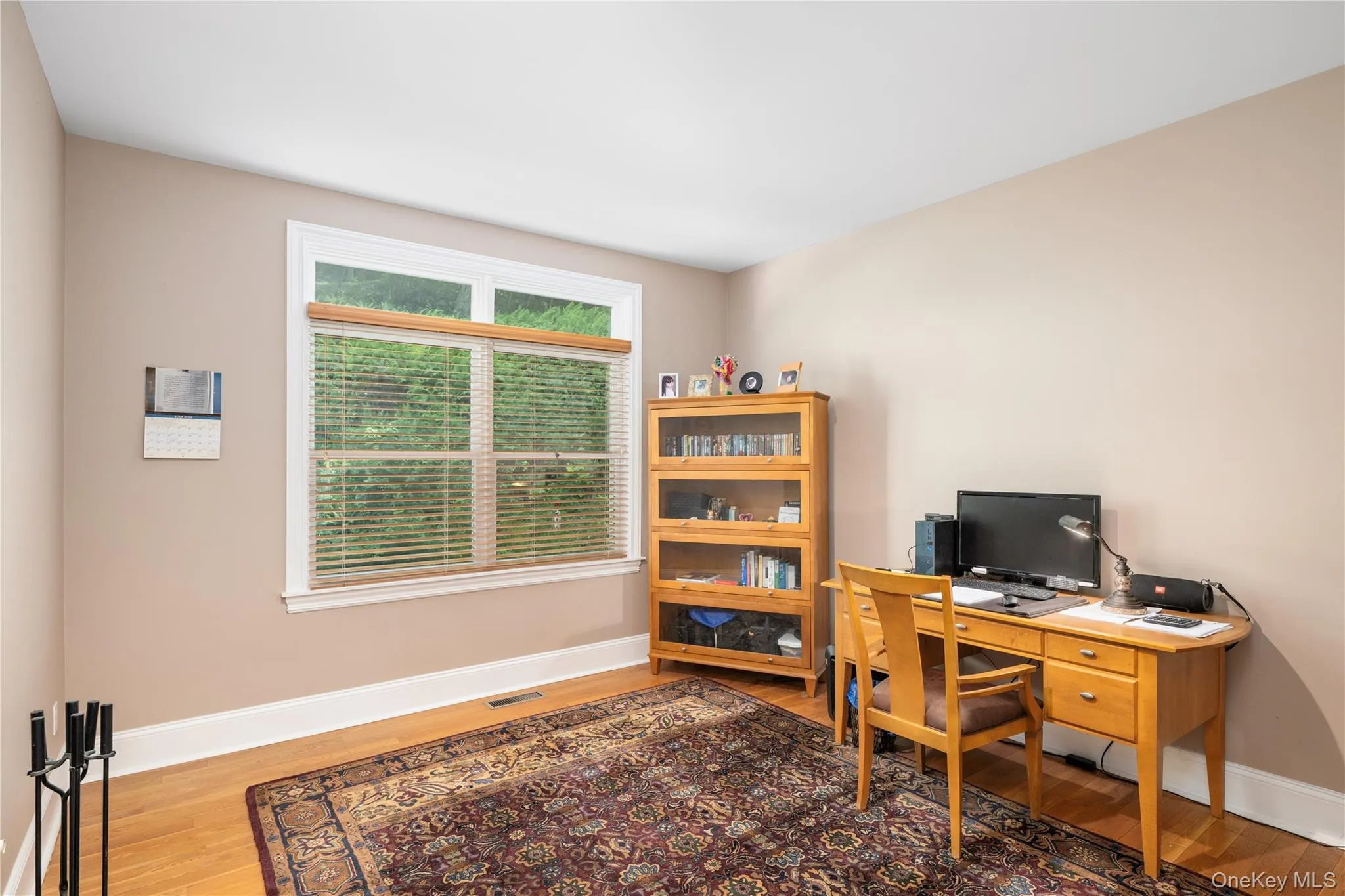 Bright room with wood-finish flooring, neutral wall tones, and white trim Bright room with wood-finish flooring, neutral wall tones, and white trim