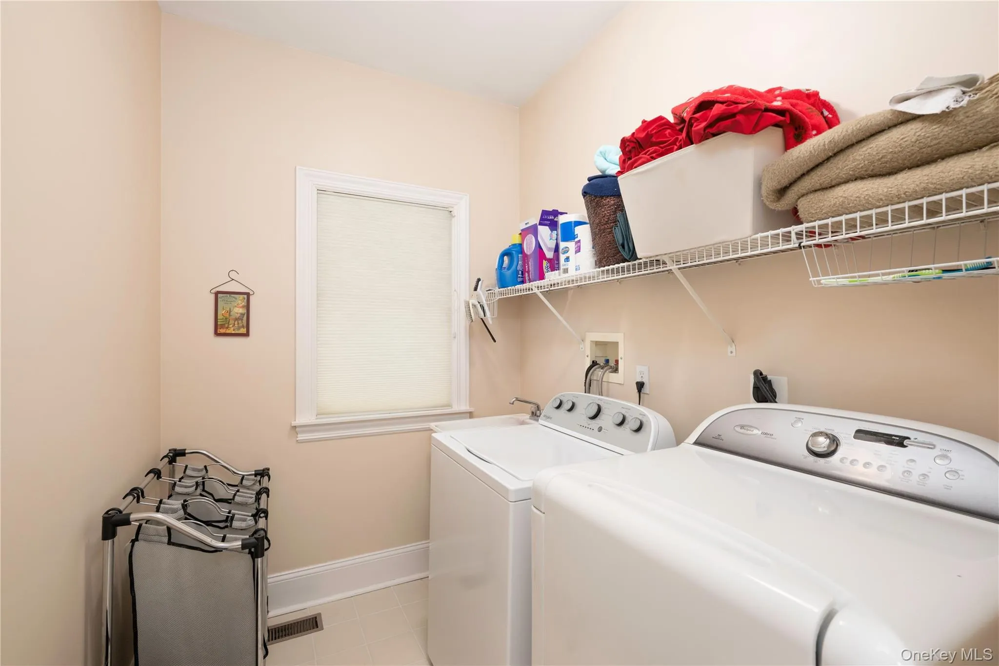 Dedicated laundry space featuring a window, built-in shelving, and light-toned wall paint Dedicated laundry space featuring a window, built-in shelving, and light-toned wall paint