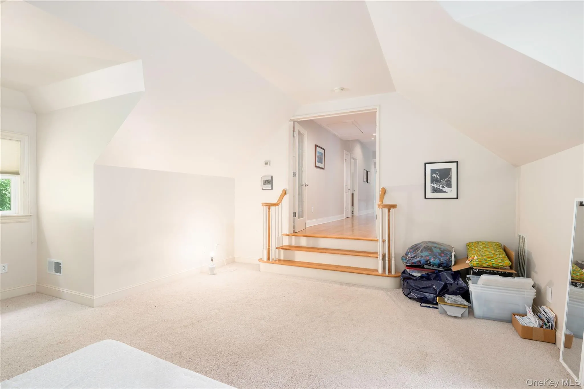 Carpeted space with sloped ceilings and a window Carpeted space with sloped ceilings and a window