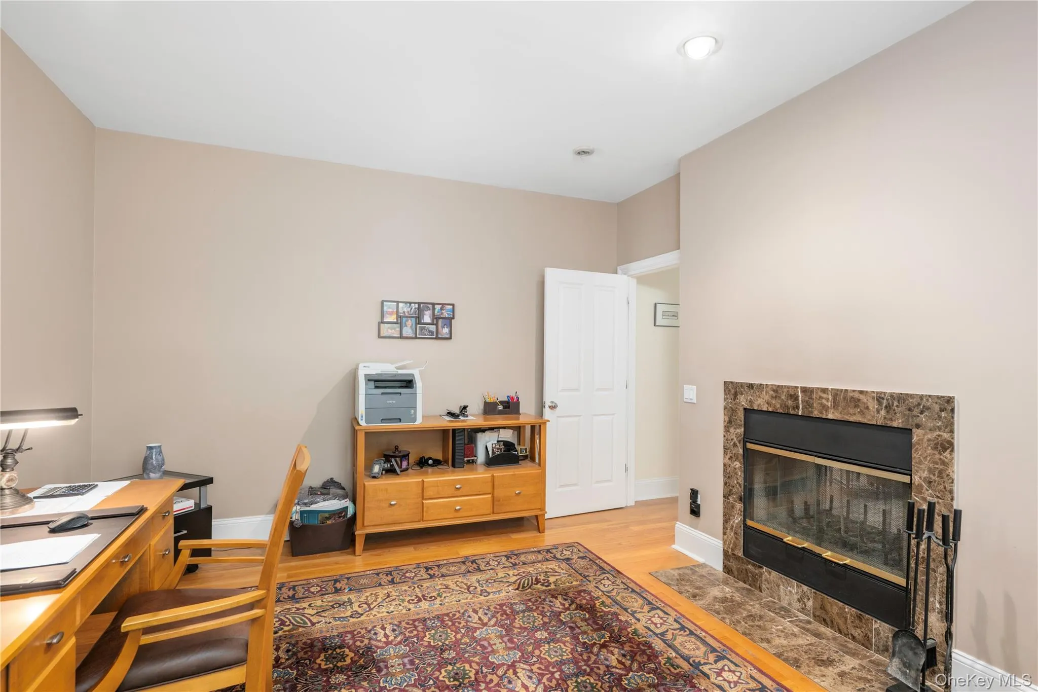Integrated fireplace with a stone-tile surround and hearth, recessed ceiling lighting, and wood-finish flooring Integrated fireplace with a stone-tile surround and hearth, recessed ceiling lighting, and wood-finish flooring