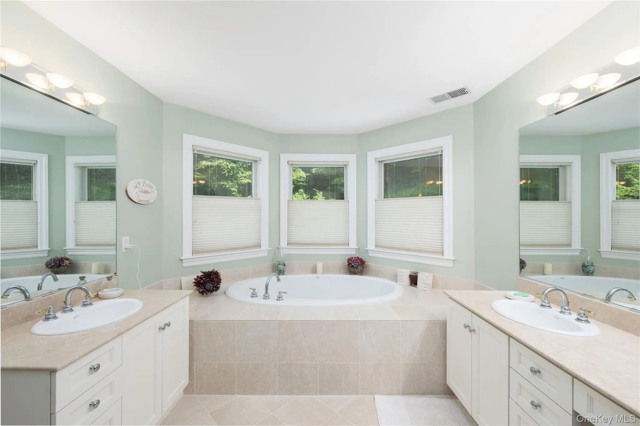 Spa-like bathroom featuring an oval soaking tub with a tiled surround Spa-like bathroom featuring an oval soaking tub with a tiled surround