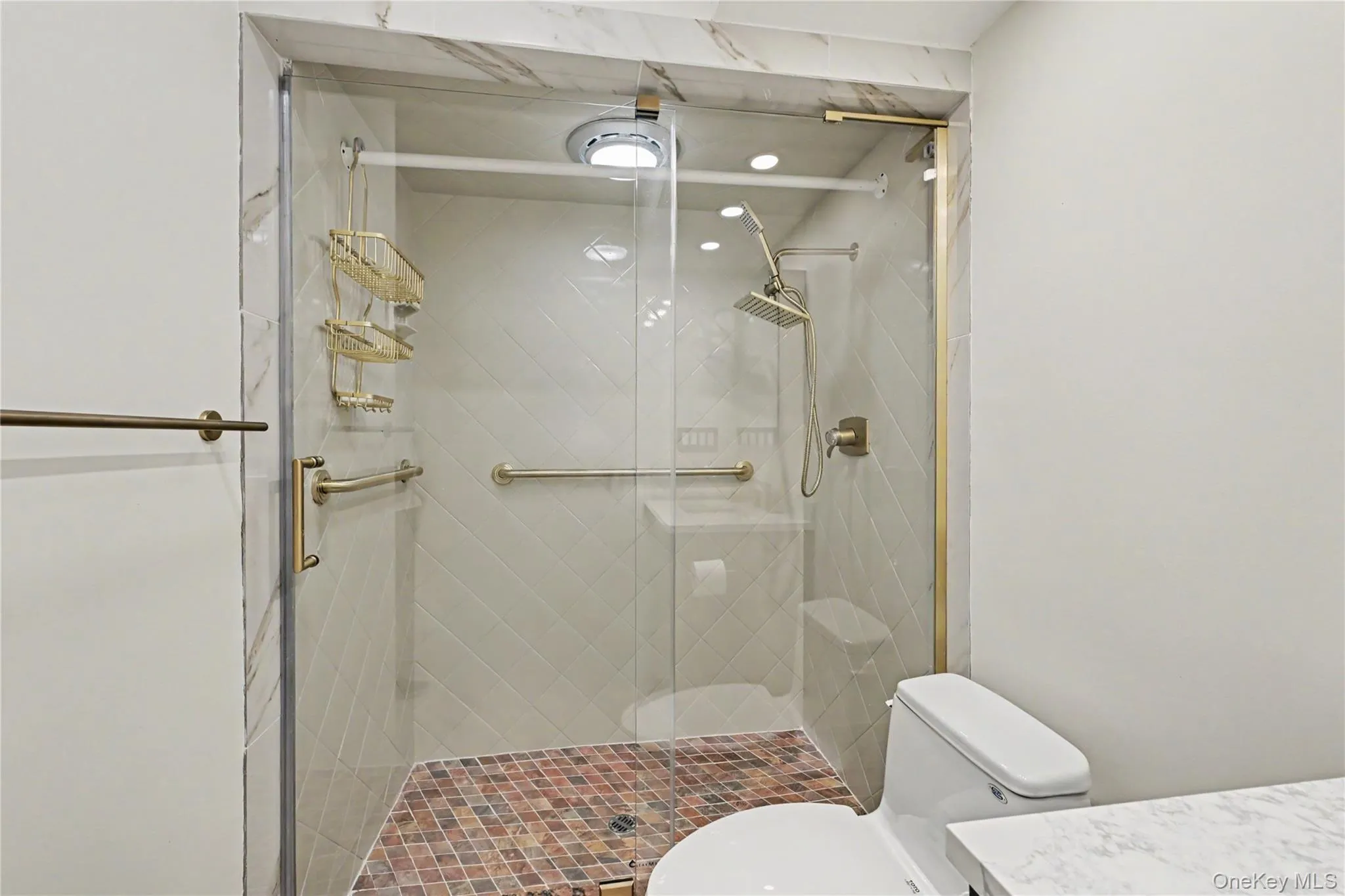 Large walk-in shower with glass door and safety grab-bars. Large walk-in shower with glass door and safety grab-bars.