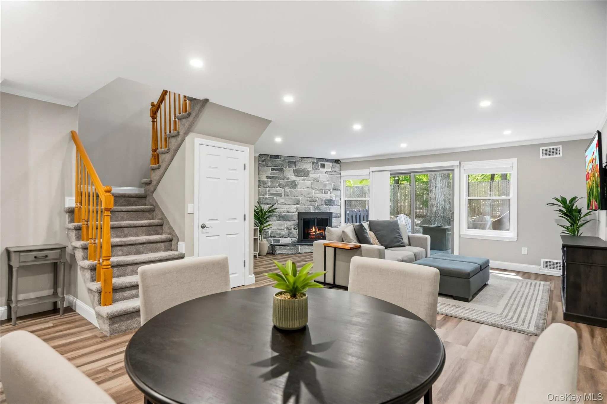 Open floor plan with dining room and living room with fireplace and sliders to new deck Open floor plan with dining room and living room with fireplace and sliders to new deck