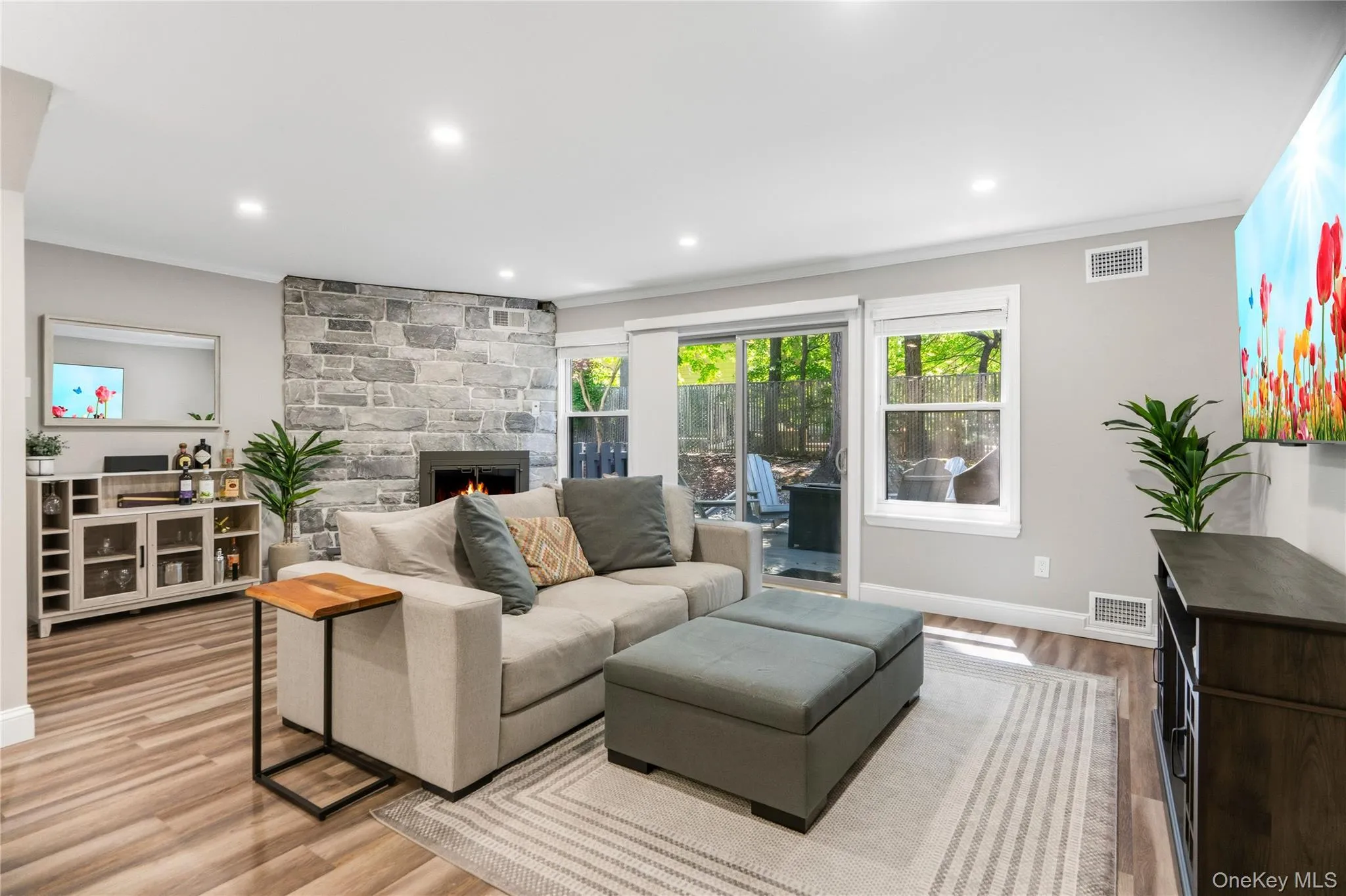 Spacious living room with wood burning fireplace and sliders to deck Spacious living room with wood burning fireplace and sliders to deck