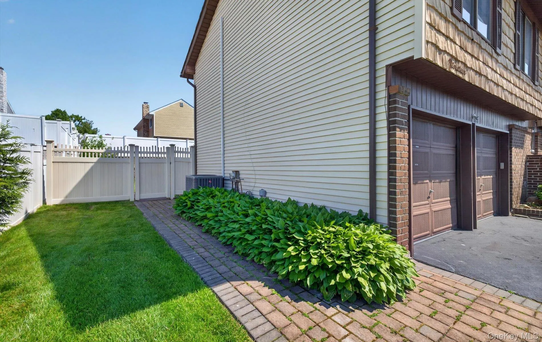 Two-car garage with panel doors, brick accents, and asphalt driveway Two-car garage with panel doors, brick accents, and asphalt driveway