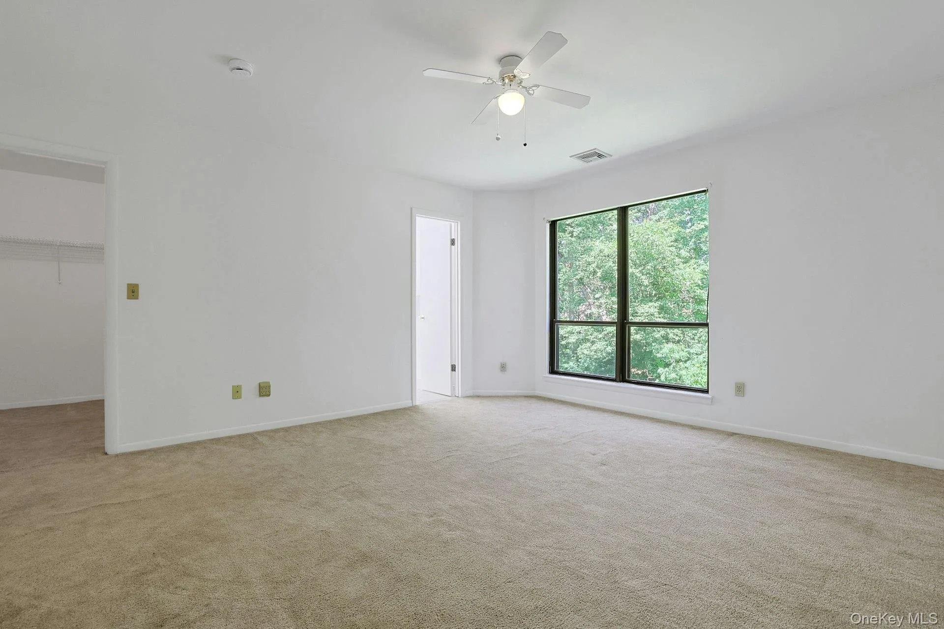 Upstairs, the primary bedroom is large, bright and comfortable, with warm and plush carpet underfoot. The large windows look out to the trees beyond. Upstairs, the primary bedroom is large, bright and comfortable, with warm and plush carpet underfoot. The large windows look out to the trees beyond.