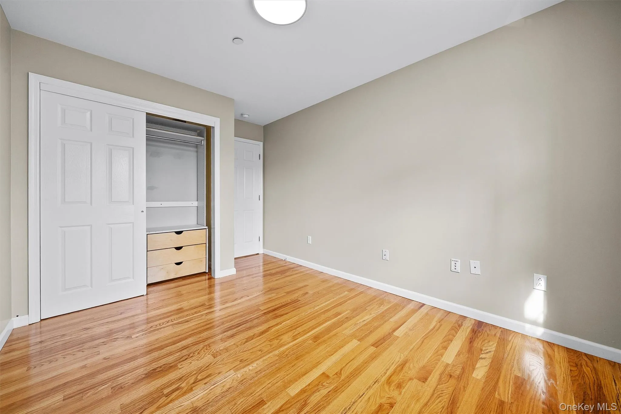 Unfurnished bedroom with a closet, light wood finished floors, and baseboards Unfurnished bedroom with a closet, light wood finished floors, and baseboards