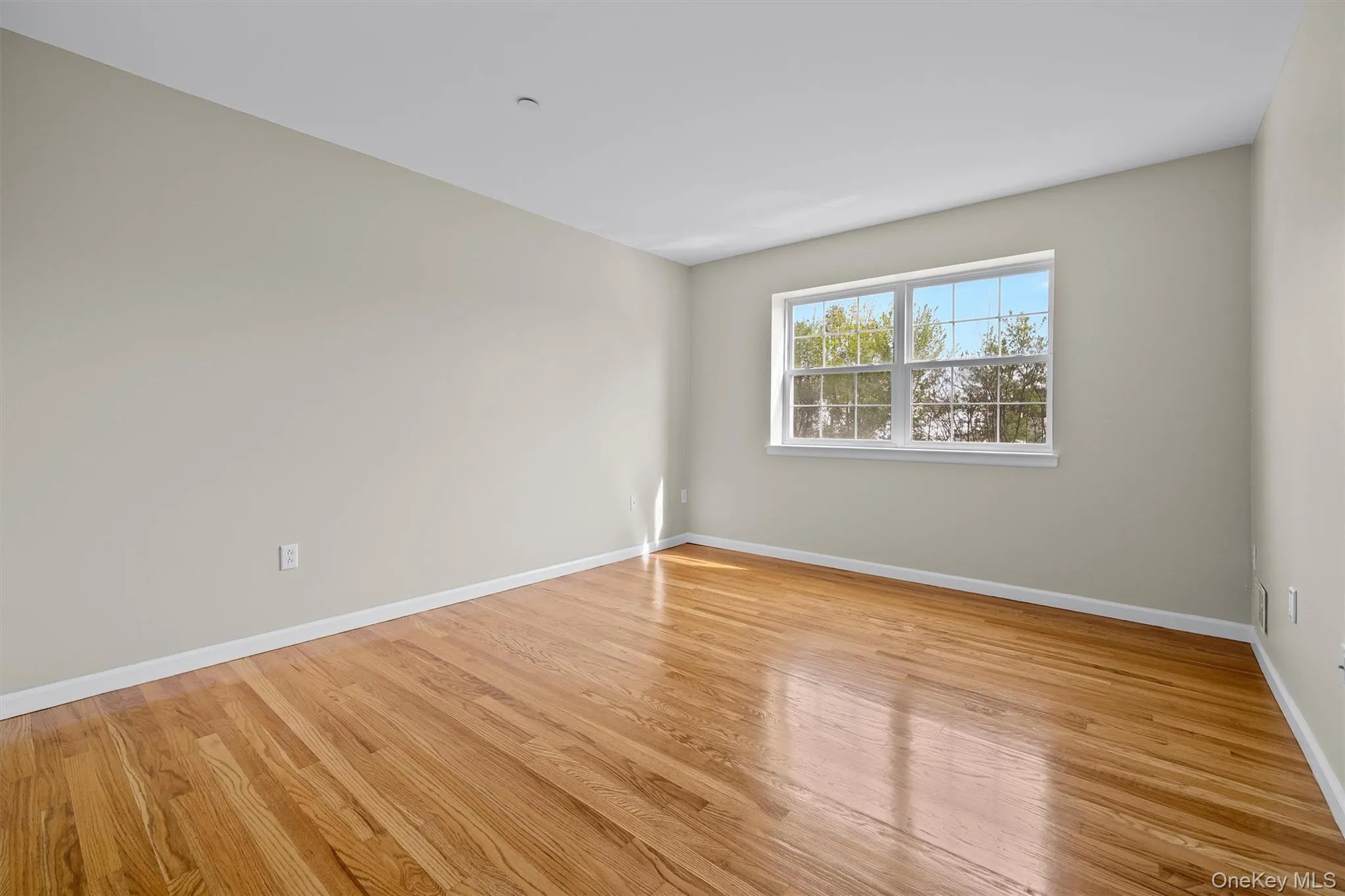 Spare room featuring baseboards and wood finished floors Spare room featuring baseboards and wood finished floors