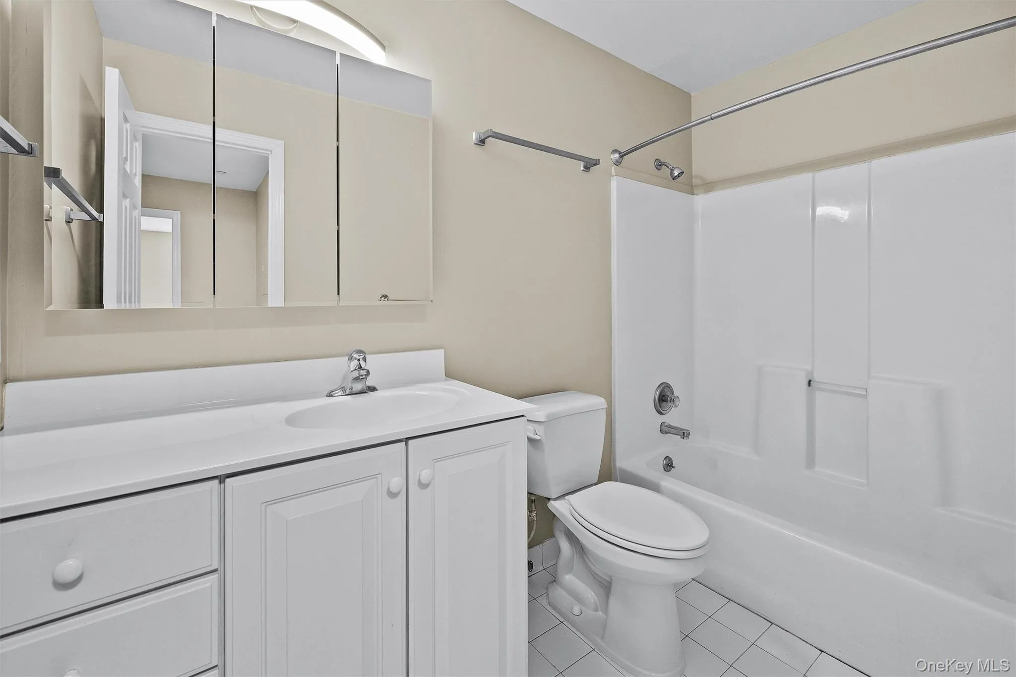 Full bathroom with vanity, toilet, tile patterned flooring, and shower / bath combination Full bathroom with vanity, toilet, tile patterned flooring, and shower / bath combination