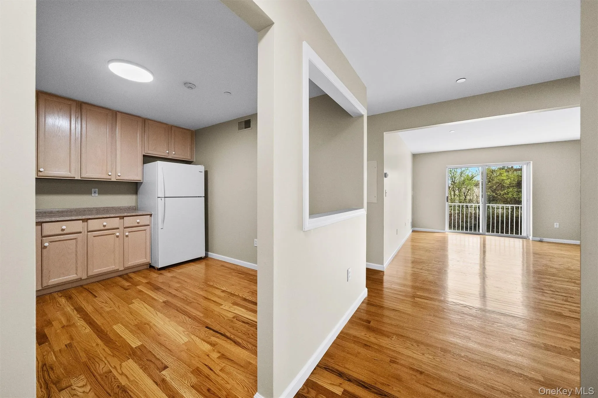 Kitchen featuring baseboards, visible vents, light wood-style flooring, and freestanding refrigerator Kitchen featuring baseboards, visible vents, light wood-style flooring, and freestanding refrigerator